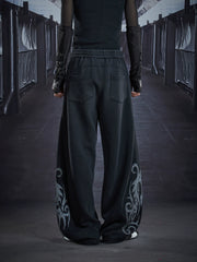 NOMANIAI Loose-fit casual trousers with a washed, distressed finish and totem print.