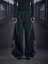 NOMANIAI Loose-fit casual trousers with a washed, distressed finish and totem print.