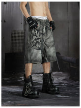 NOMANIAI Y2K loose-fit denim shorts with hand-drawn motifs and studs.