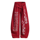 NOMANIAI Loose-fitting trousers with a totem print and Y2K-style lace-up detailing.