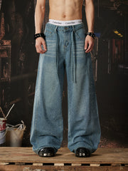 NOMANIAI Loose-fit, acid-washed, distressed denim jeans featuring rhinestone-studded streamers.