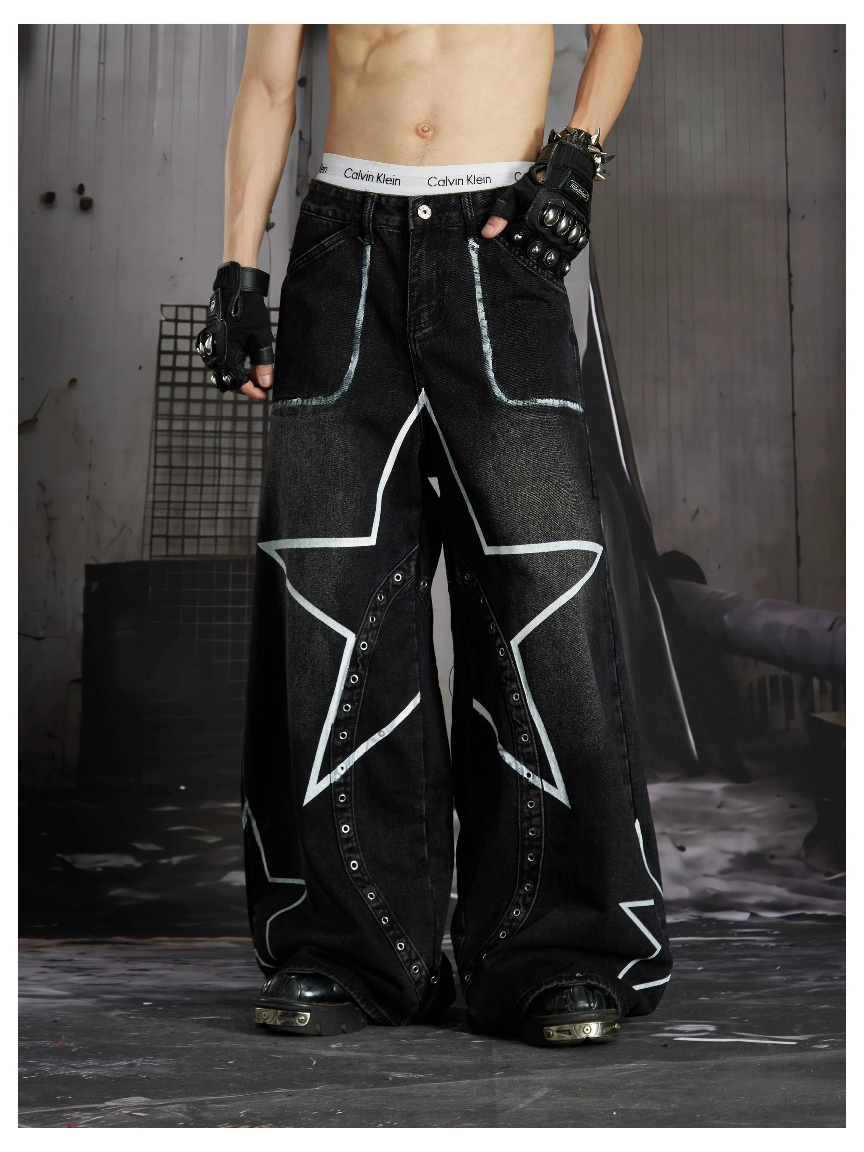 NOMANIAI  Hand-painted star and stud detail wide-leg jeans with a washed, distressed finish.