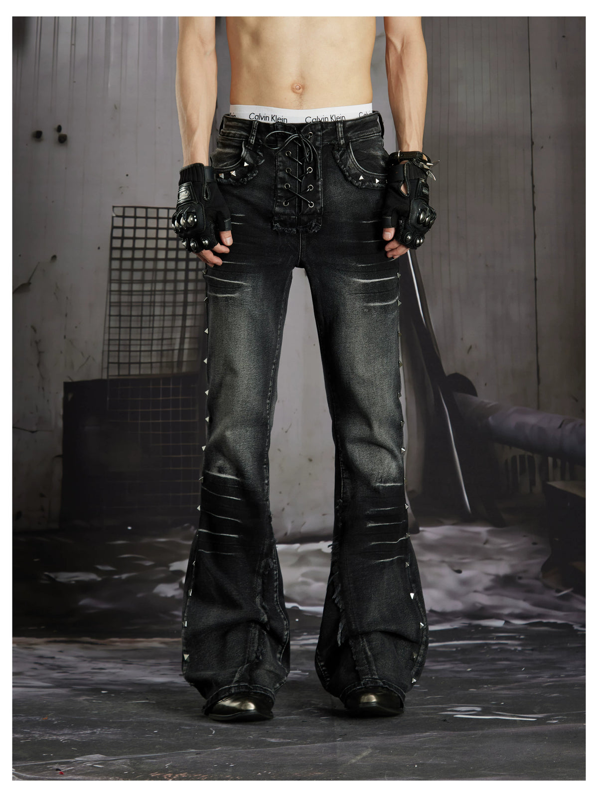 NOMANIAI Distressed, slim-fit, slight-flare jeans with studs—dark streetwear style.