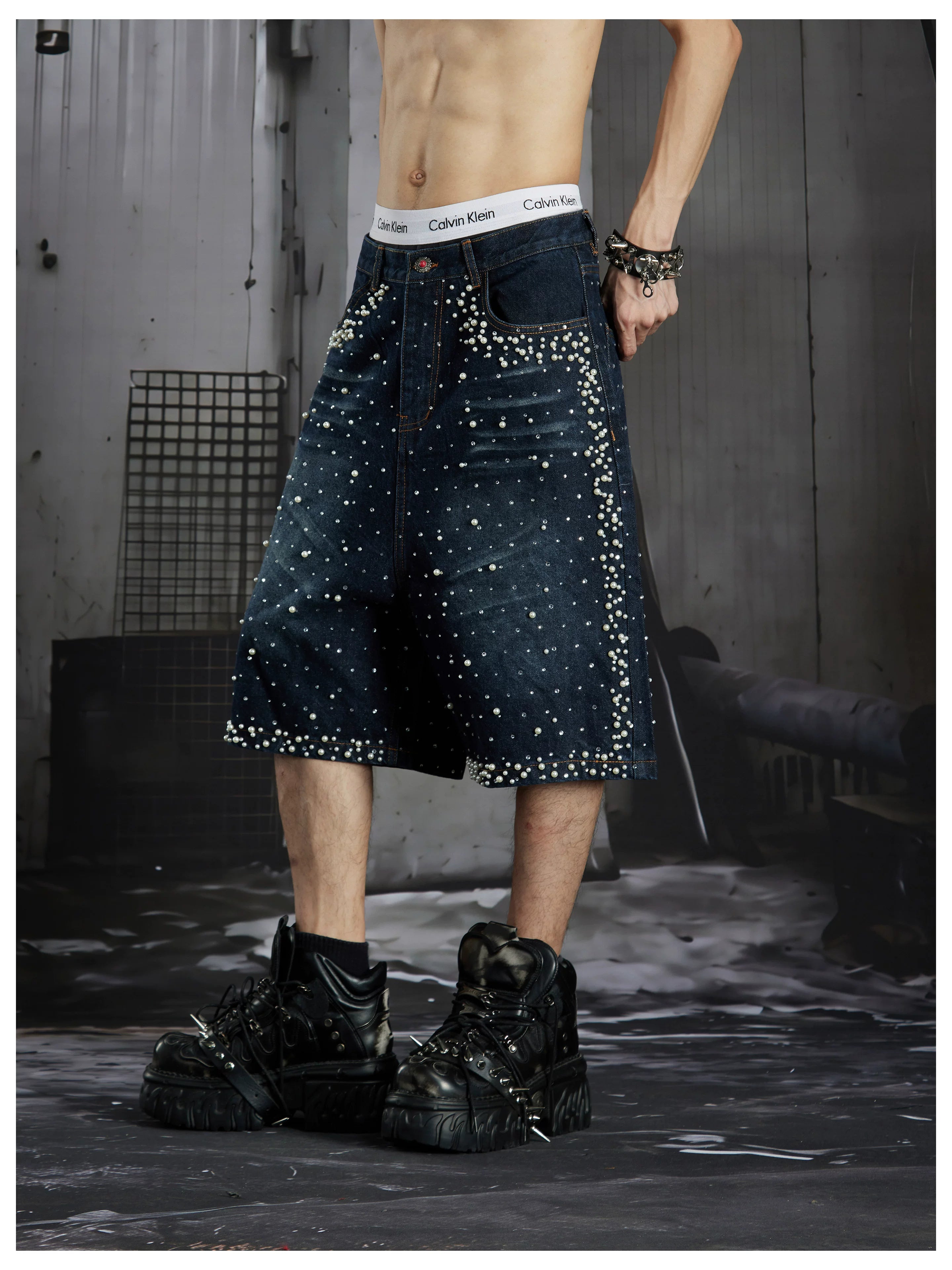 NOMANIAI  Oversized, cropped, studded denim jeans with a punk-style distressed wash.