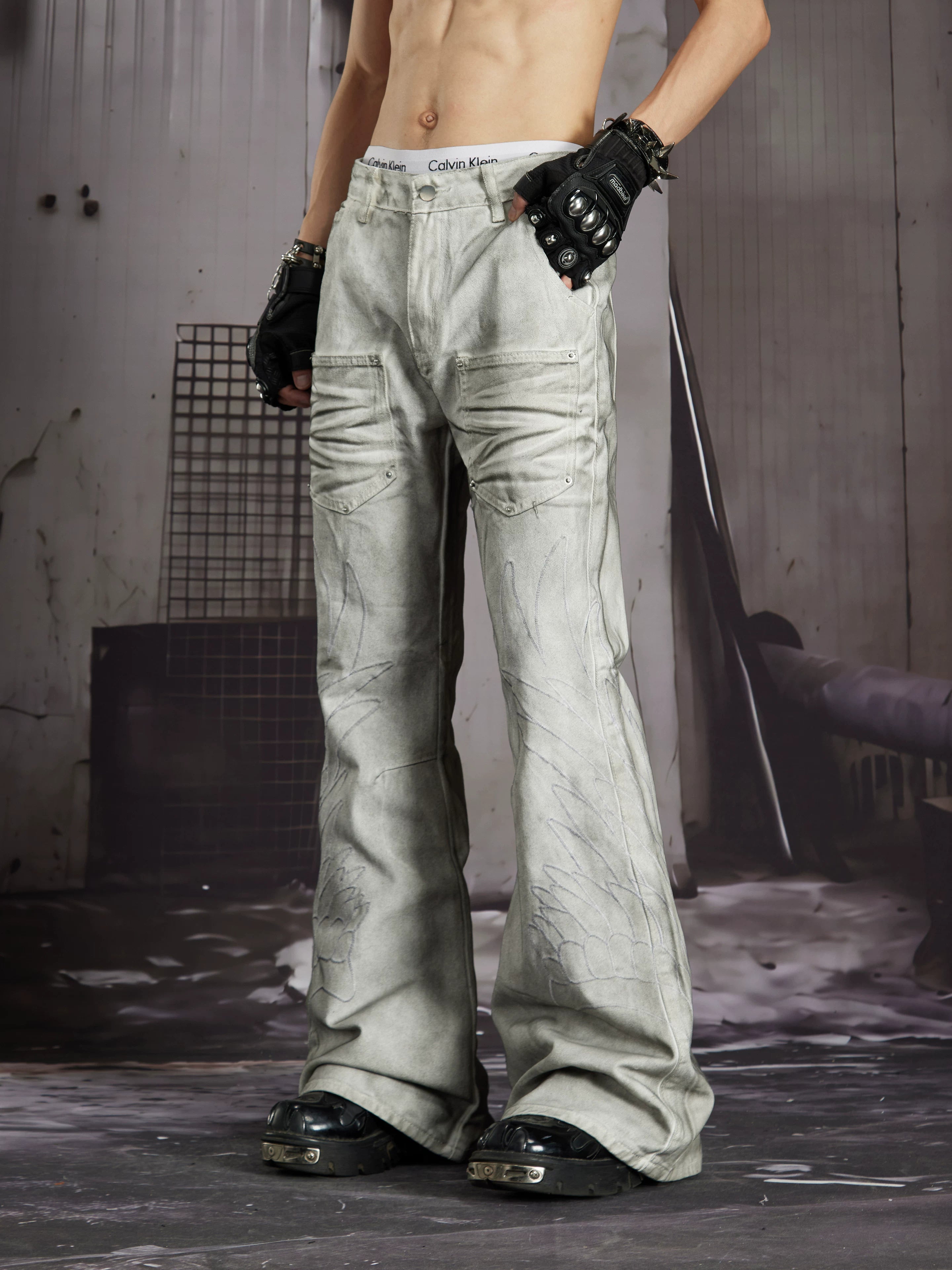 NOMANIAI Edgy, dark-style street-look flared jeans with paint-splatter and stud details.