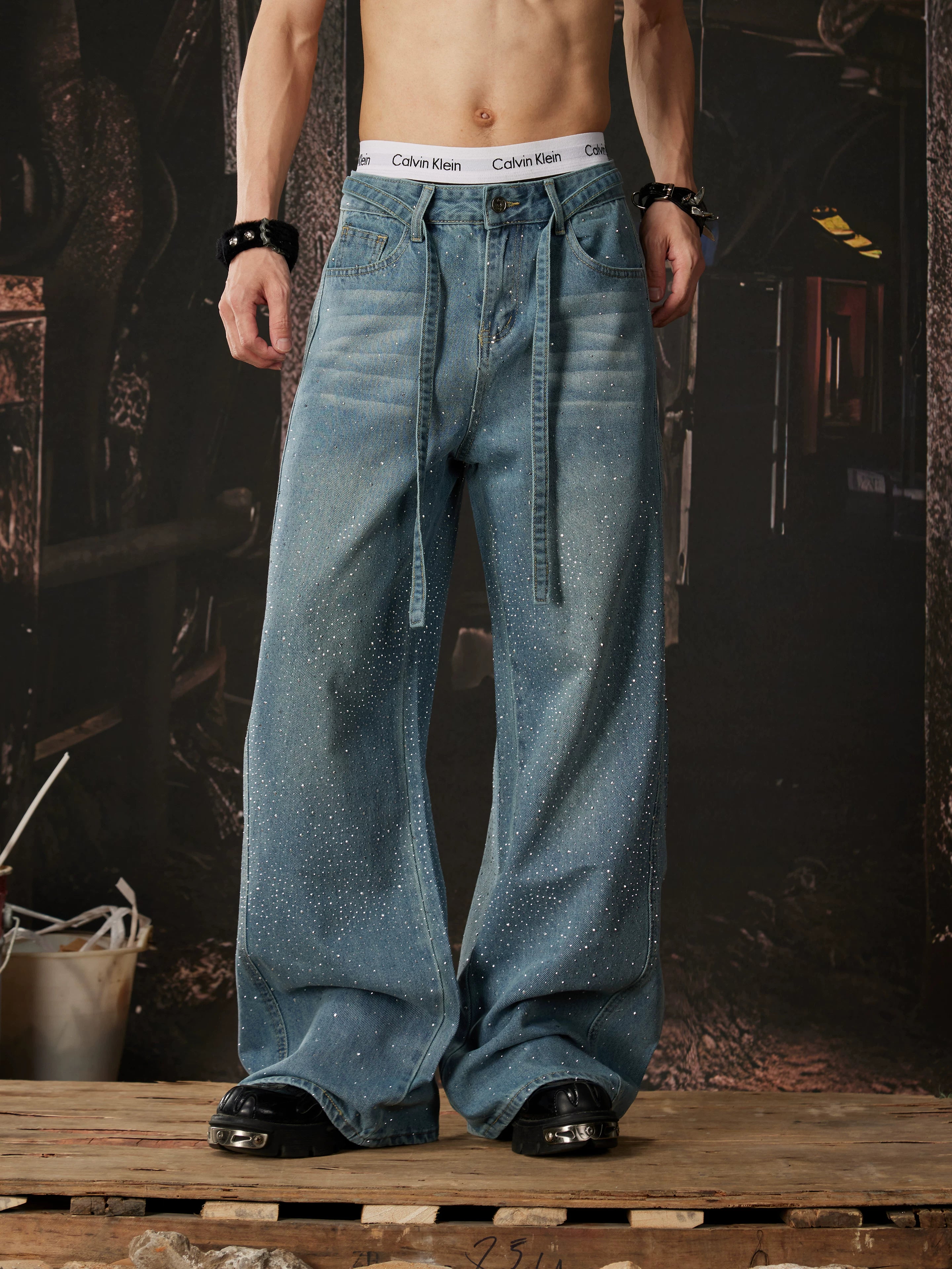 NOMANIAI  Loose-fit, acid-washed, distressed denim jeans featuring rhinestone-studded streamers.