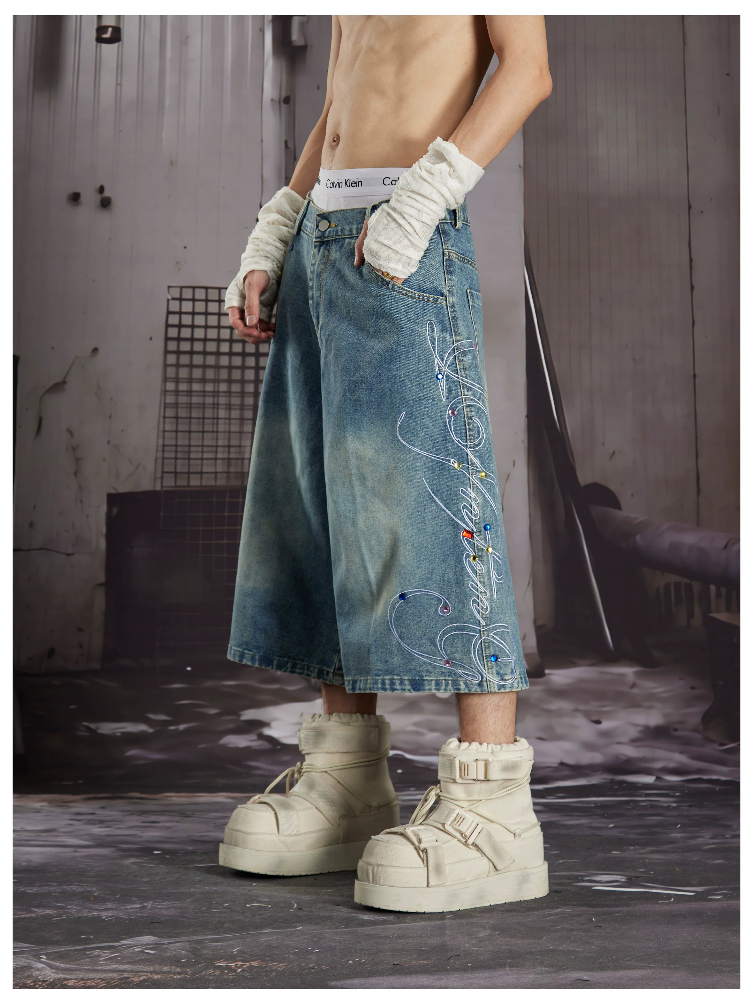 NOMANIAI Loose-fit cropped jeans with rhinestone embellishments.