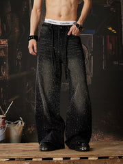 NOMANIAI  Loose-fit, acid-washed, distressed denim jeans featuring rhinestone-studded streamers.