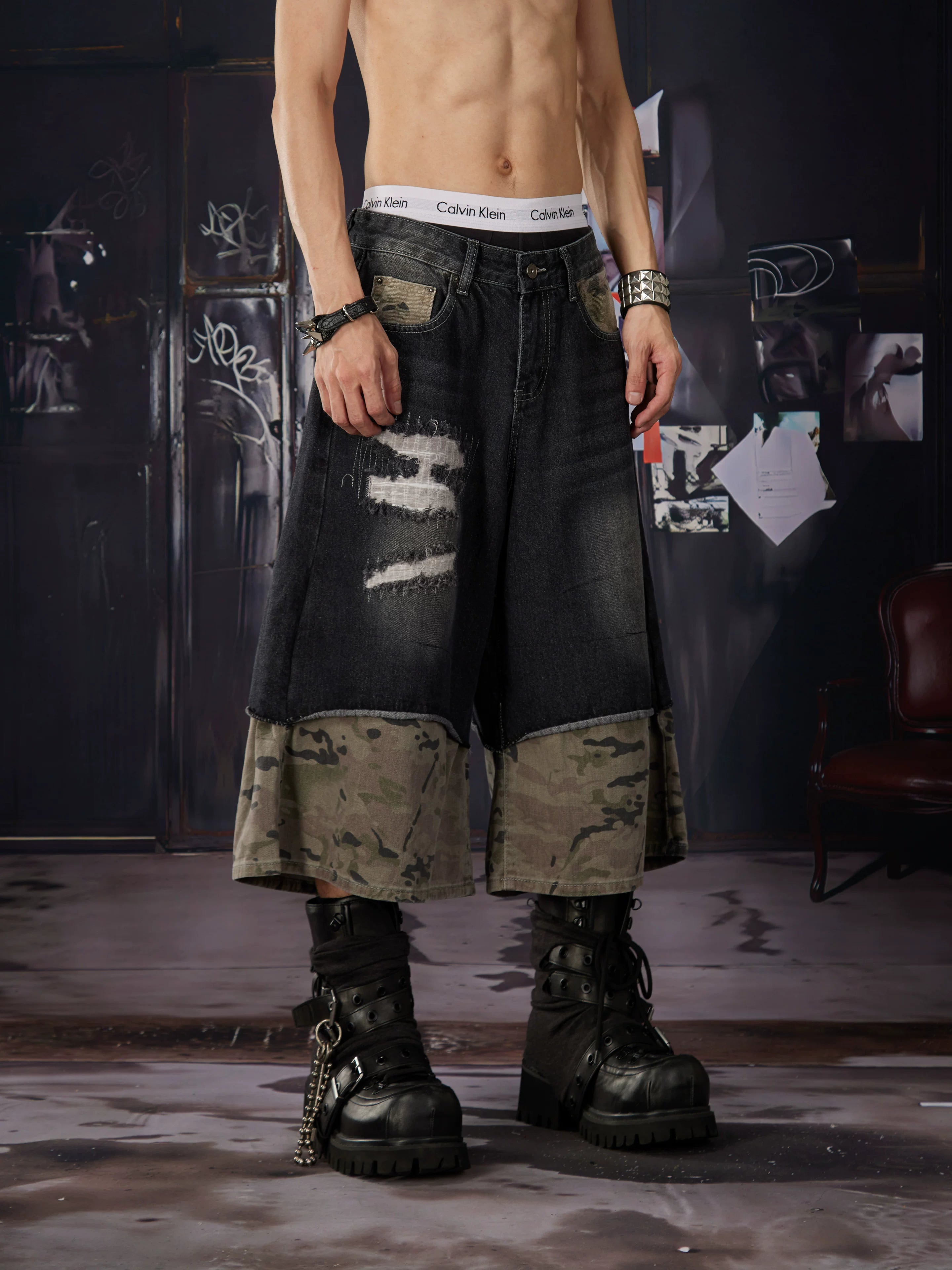 NOMANIAI Loose-fit, cropped pants featuring a "faux-layered" design, camouflage print, and a washed, distressed finish.