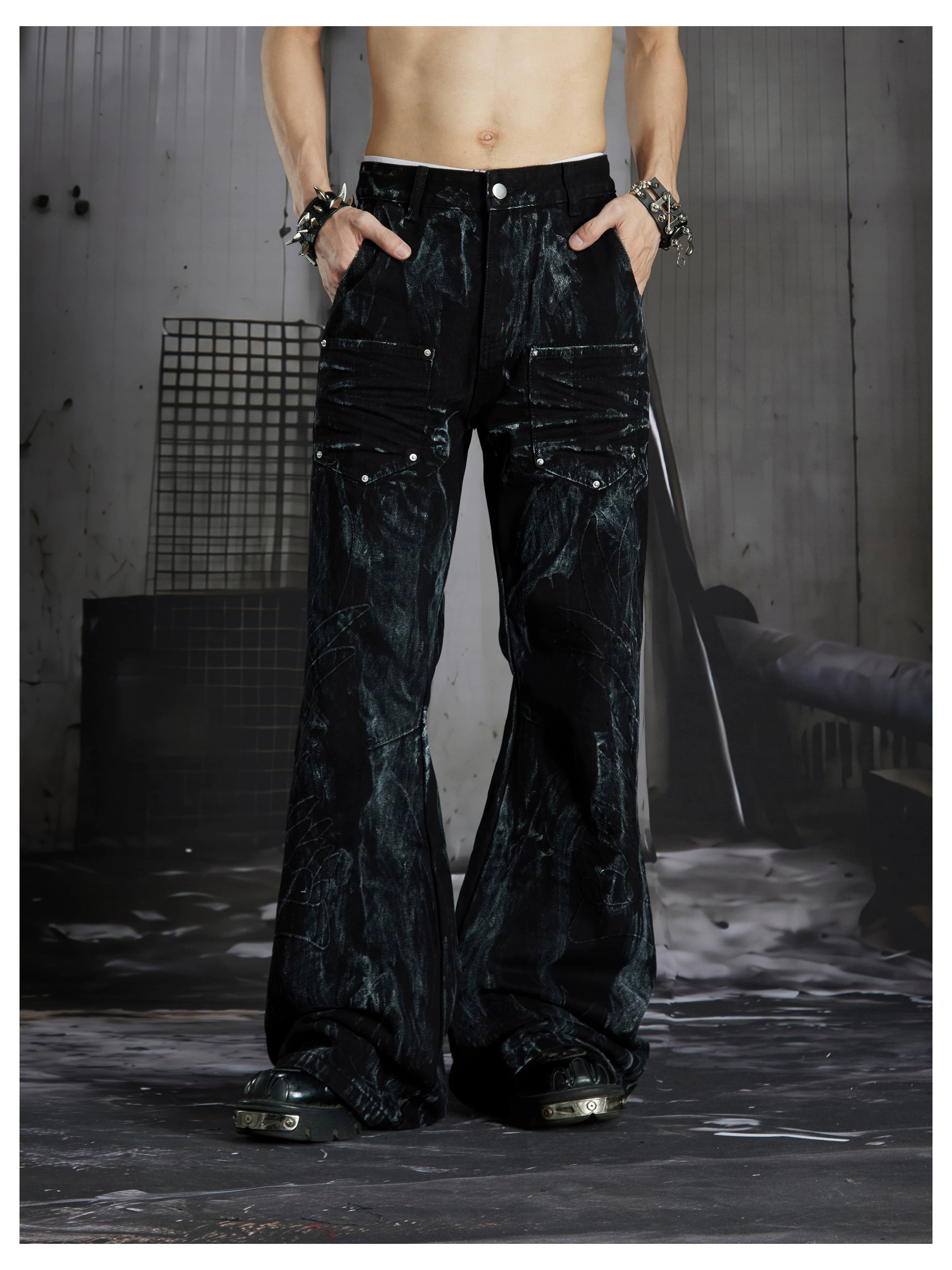 NOMANIAI Edgy, dark-style street-look flared jeans with paint-splatter and stud details.
