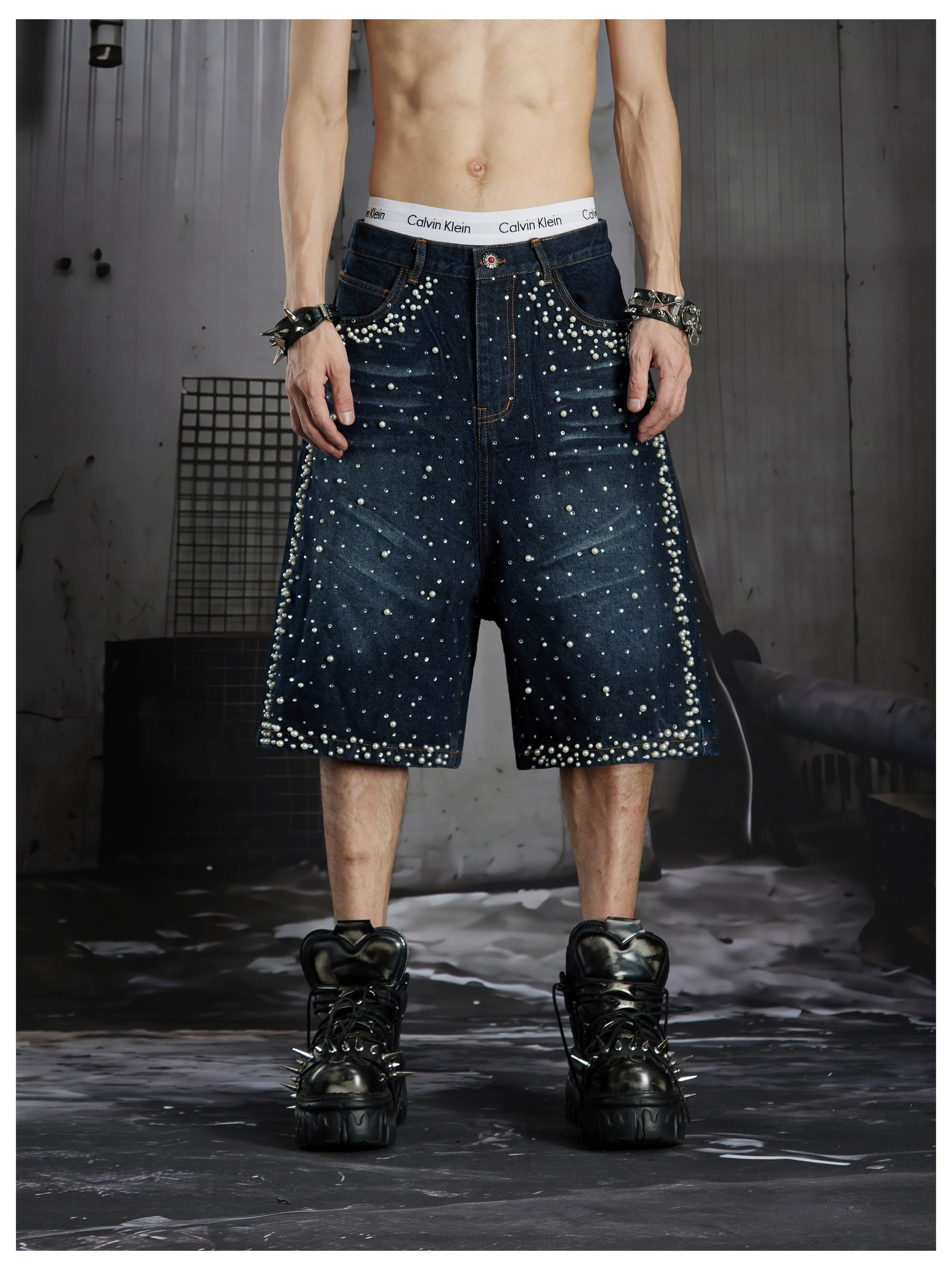 NOMANIAI  Oversized, cropped, studded denim jeans with a punk-style distressed wash.
