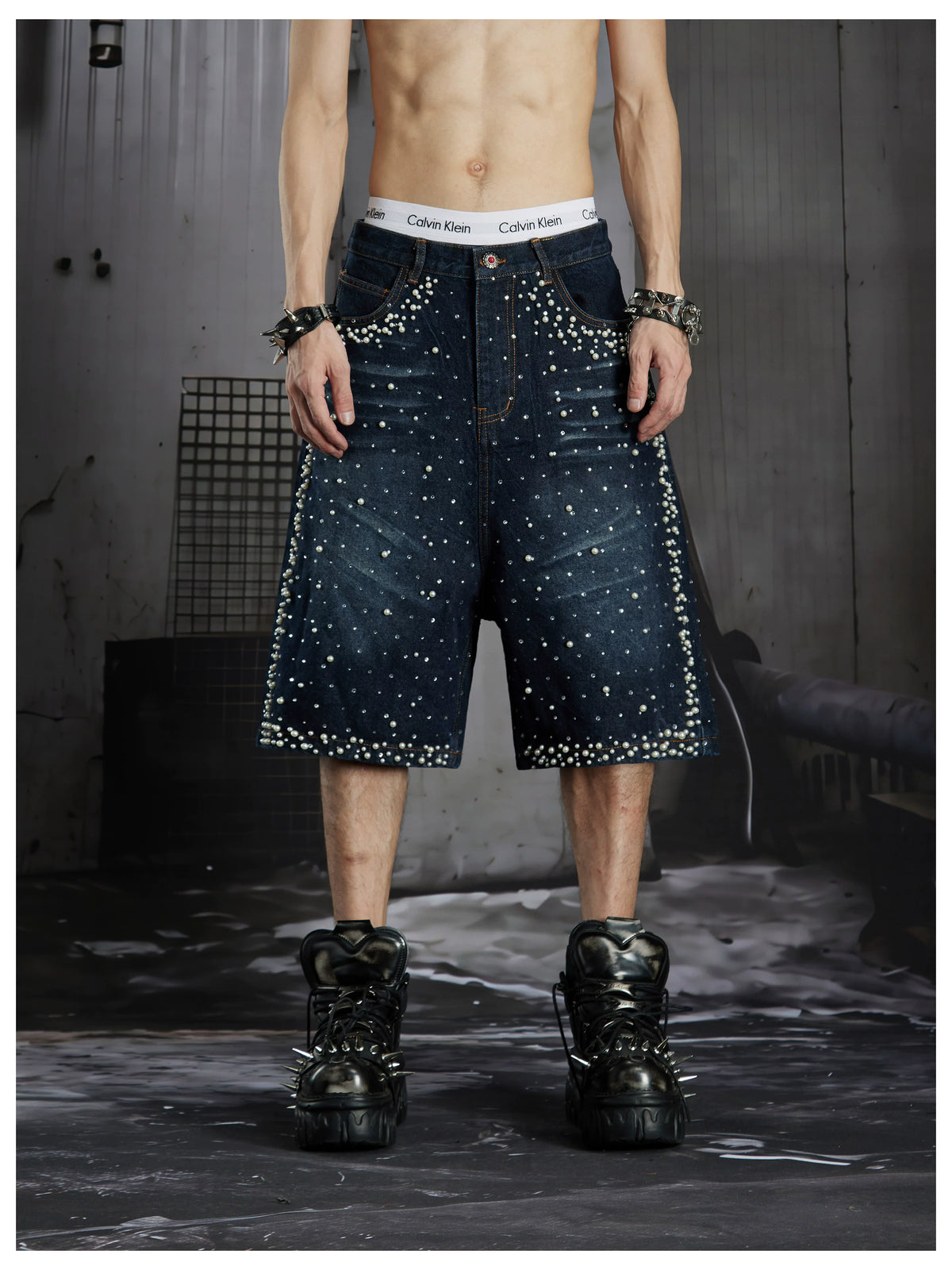 NOMANIAI  Oversized, cropped, studded denim jeans with a punk-style distressed wash.