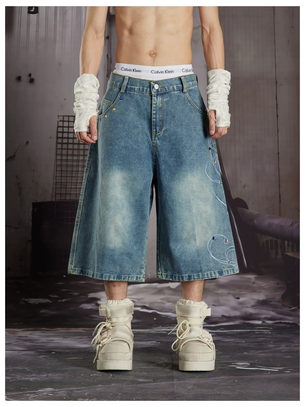 NOMANIAI Cropped jeans with rhinestone and embroidery totem design.