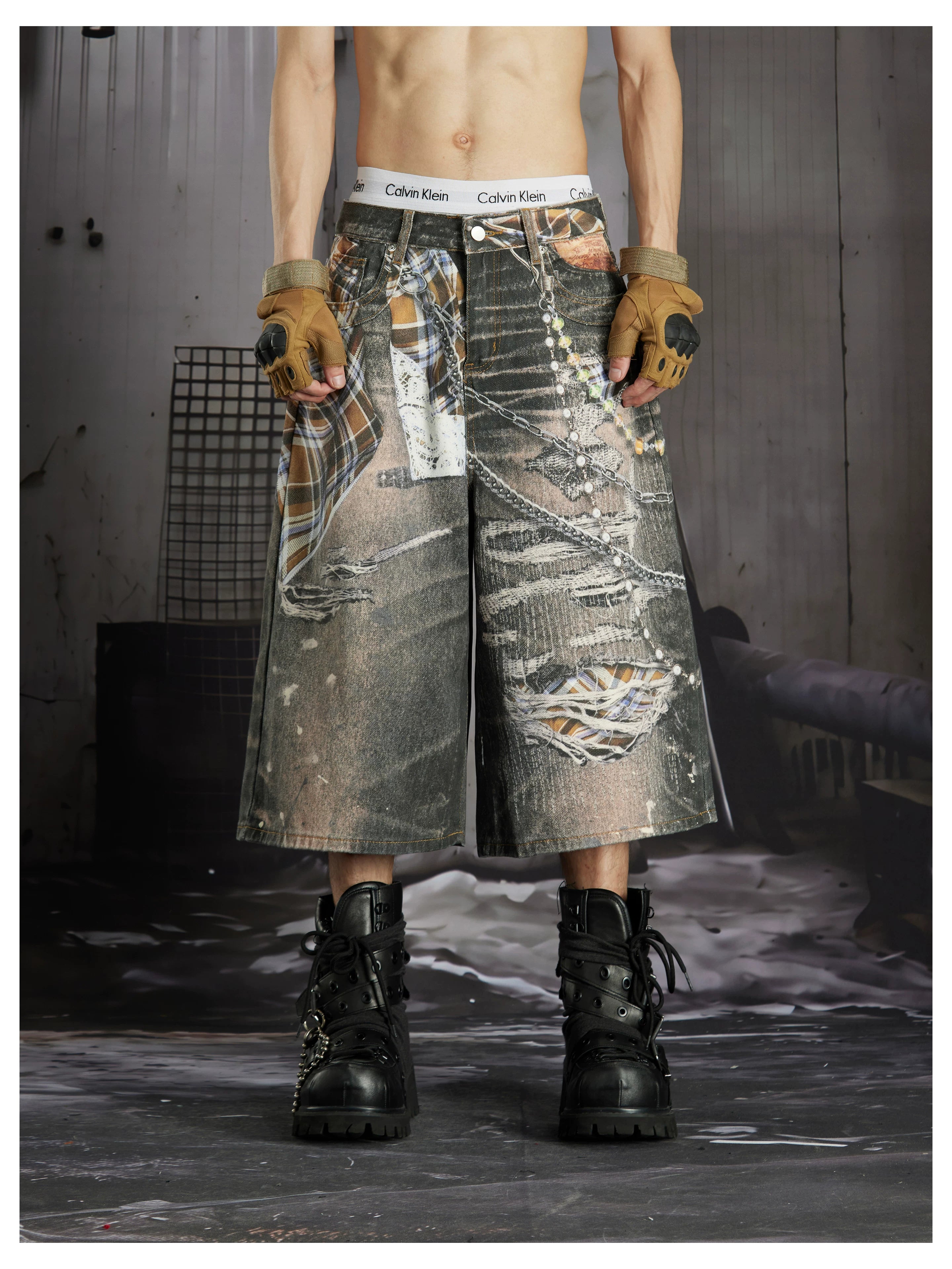 NOMANIAI  Loose-fit cropped trousers featuring a 3D-printed plaid pattern and chain detailing.