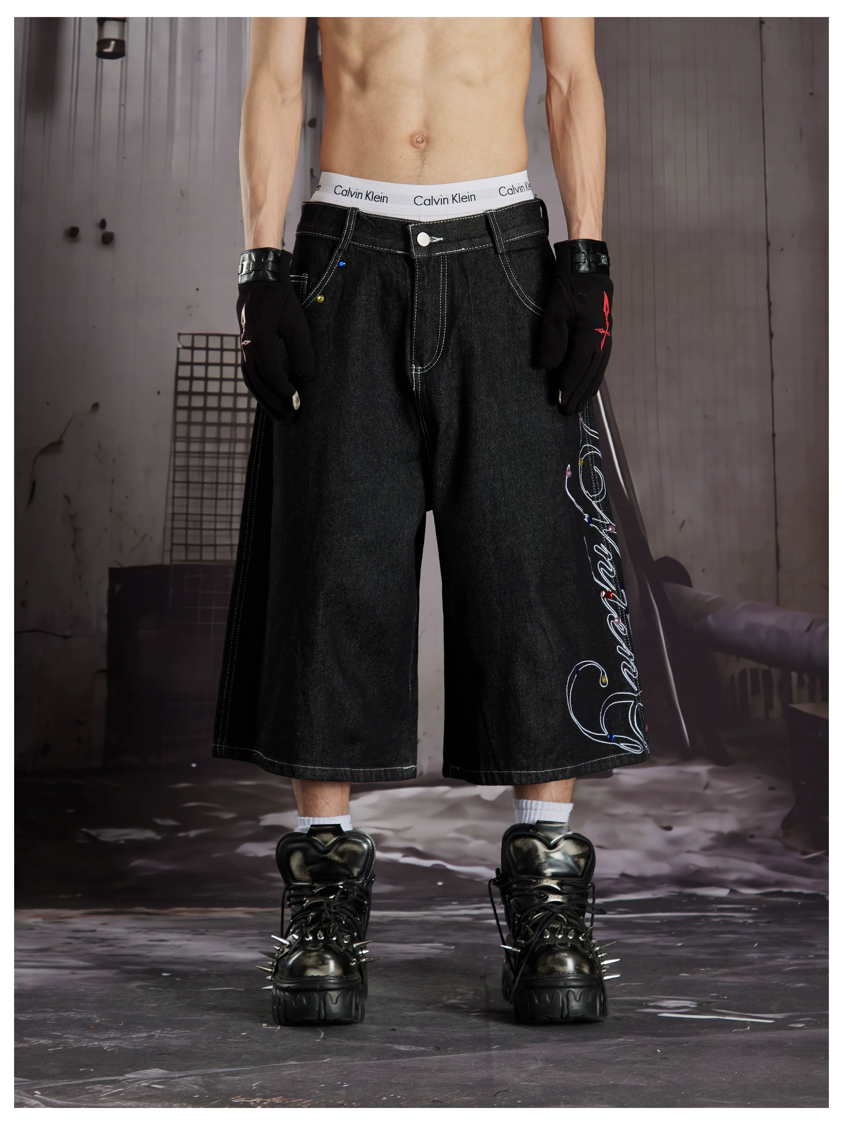 NOMANIAI Cropped jeans with rhinestone and embroidery totem design.