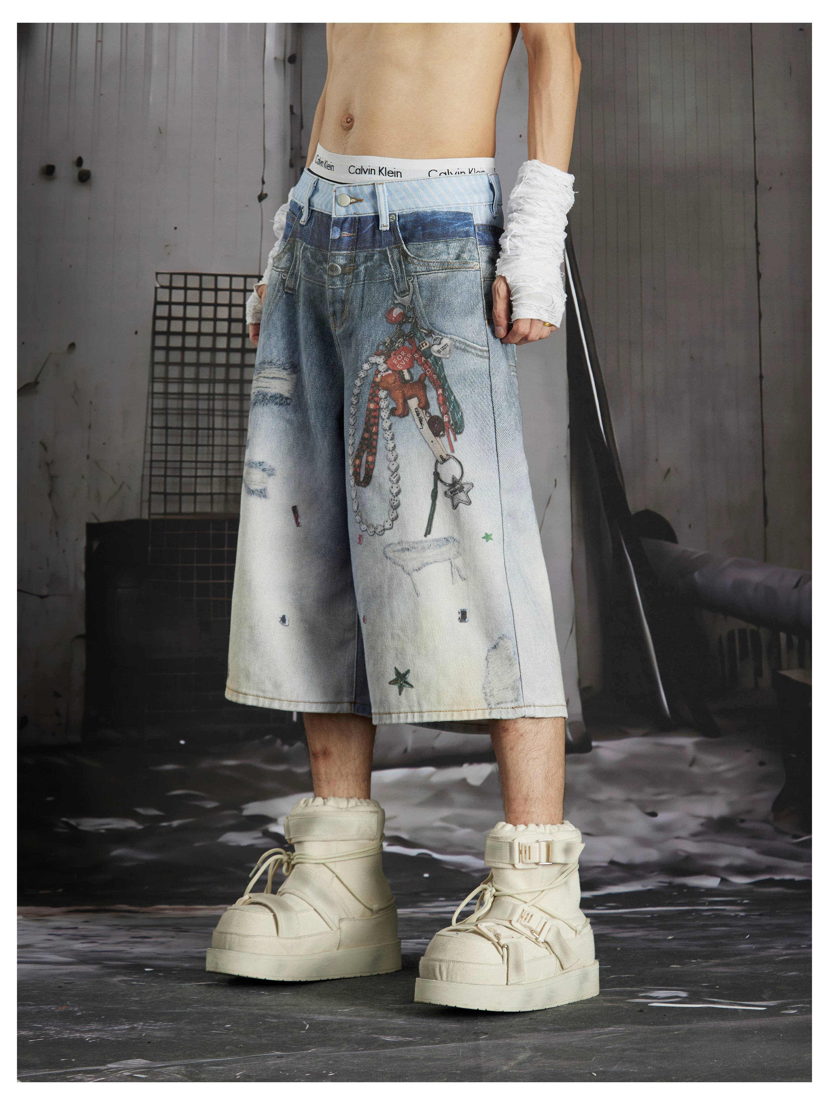 NOMANIAI Y2K-style loose-fit cropped pants featuring a triple-waistband design and chain charm detail.