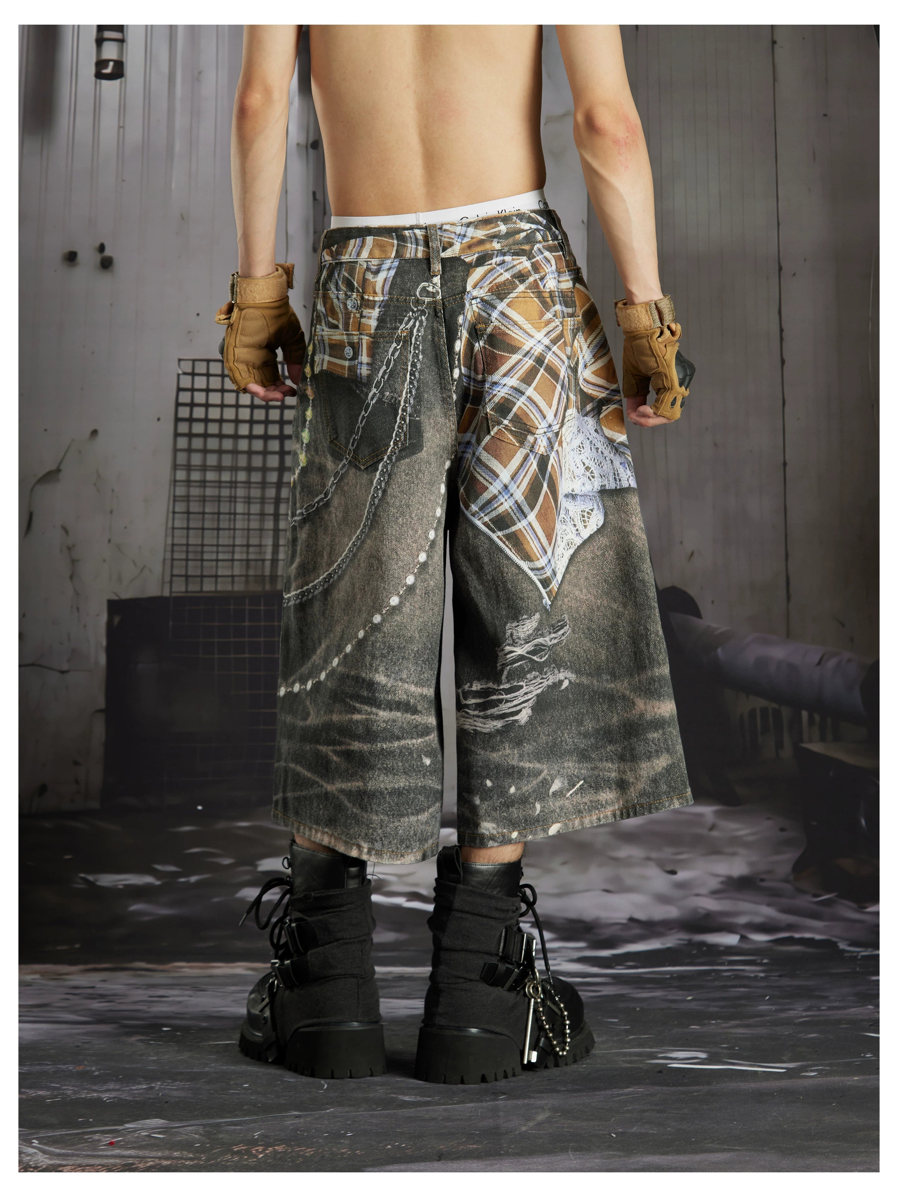 NOMANIAI  Loose-fit cropped trousers featuring a 3D-printed plaid pattern and chain detailing.