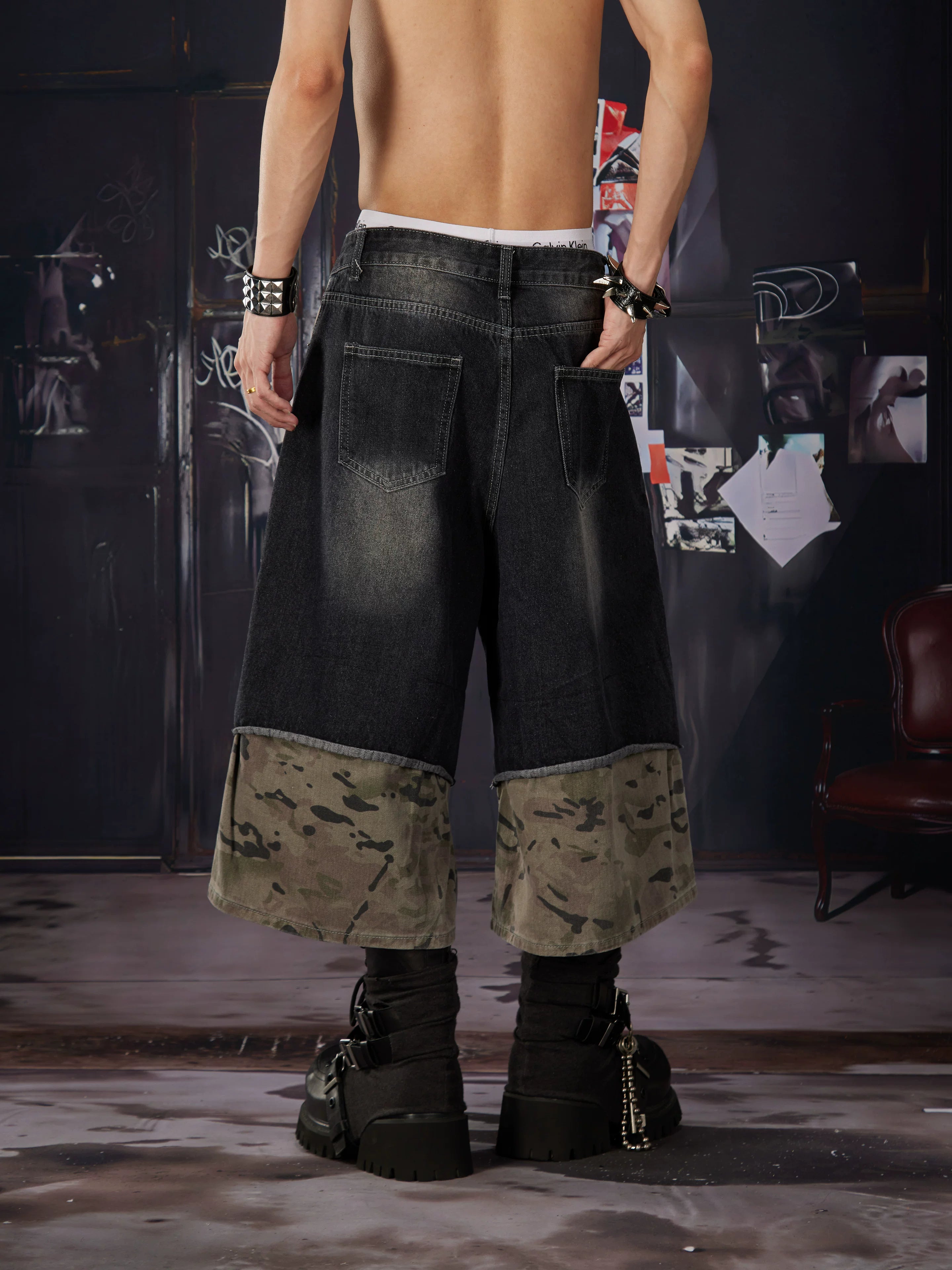 NOMANIAI Loose-fit, cropped pants featuring a "faux-layered" design, camouflage print, and a washed, distressed finish.