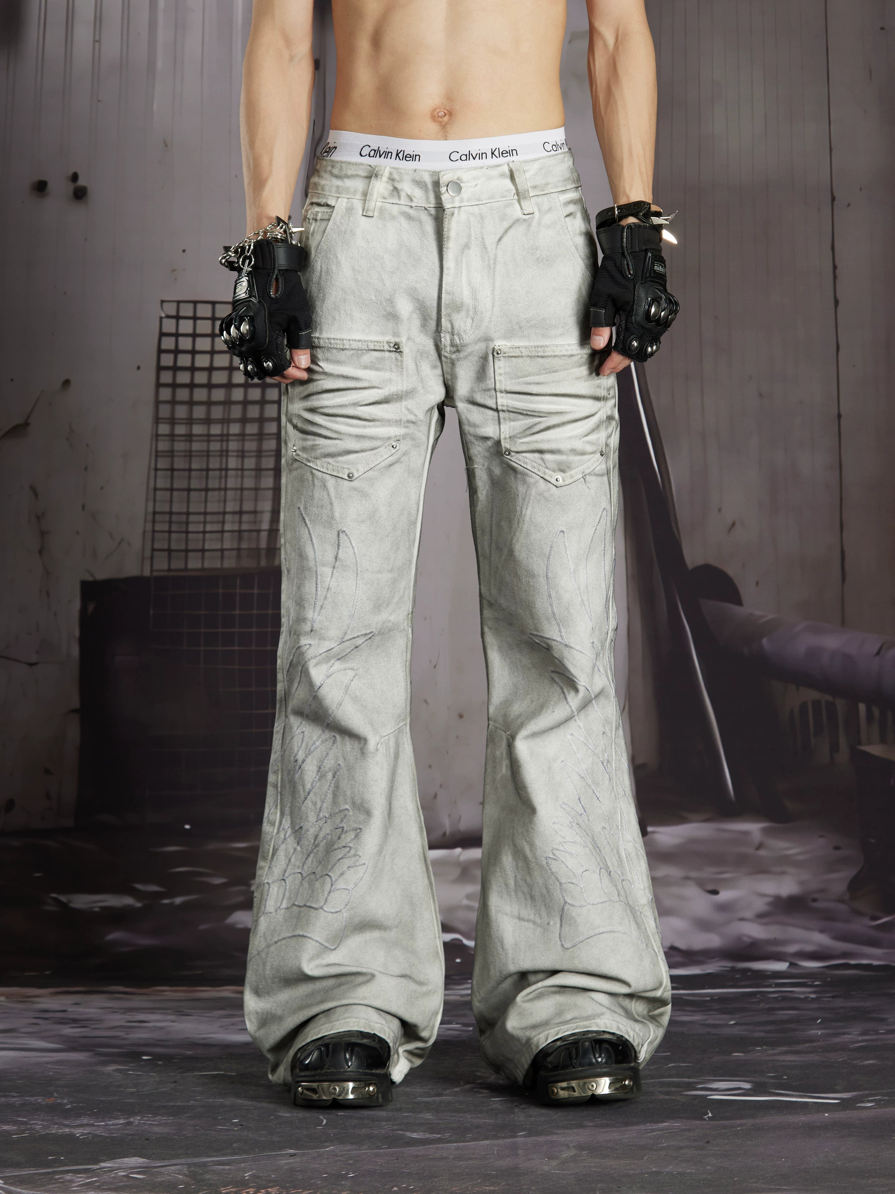 NOMANIAI Edgy, dark-style street-look flared jeans with paint-splatter and stud details.
