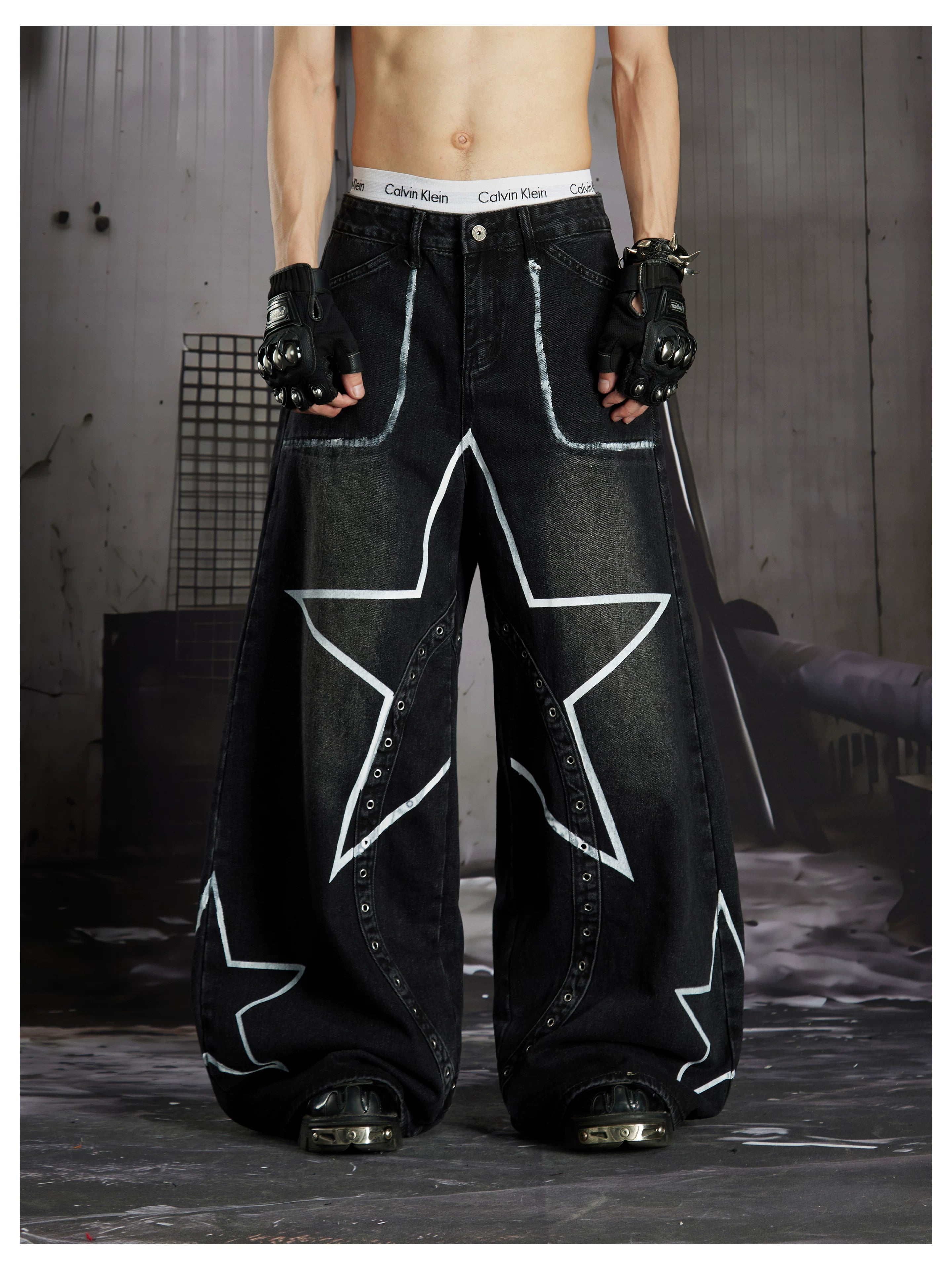 NOMANIAI  Hand-painted star and stud detail wide-leg jeans with a washed, distressed finish.
