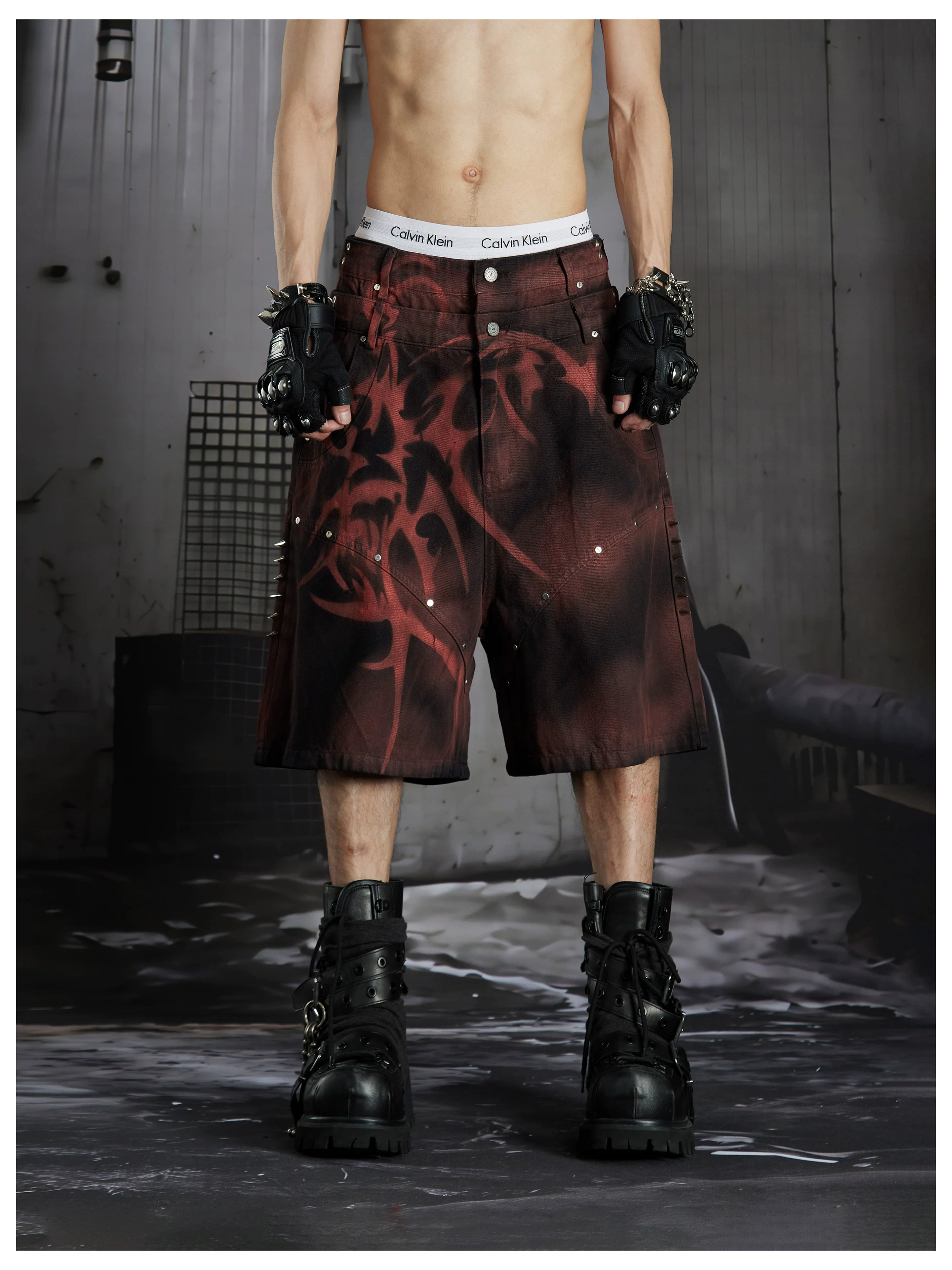 NOMANIAI Y2K loose-fit denim shorts with hand-drawn motifs and studs.