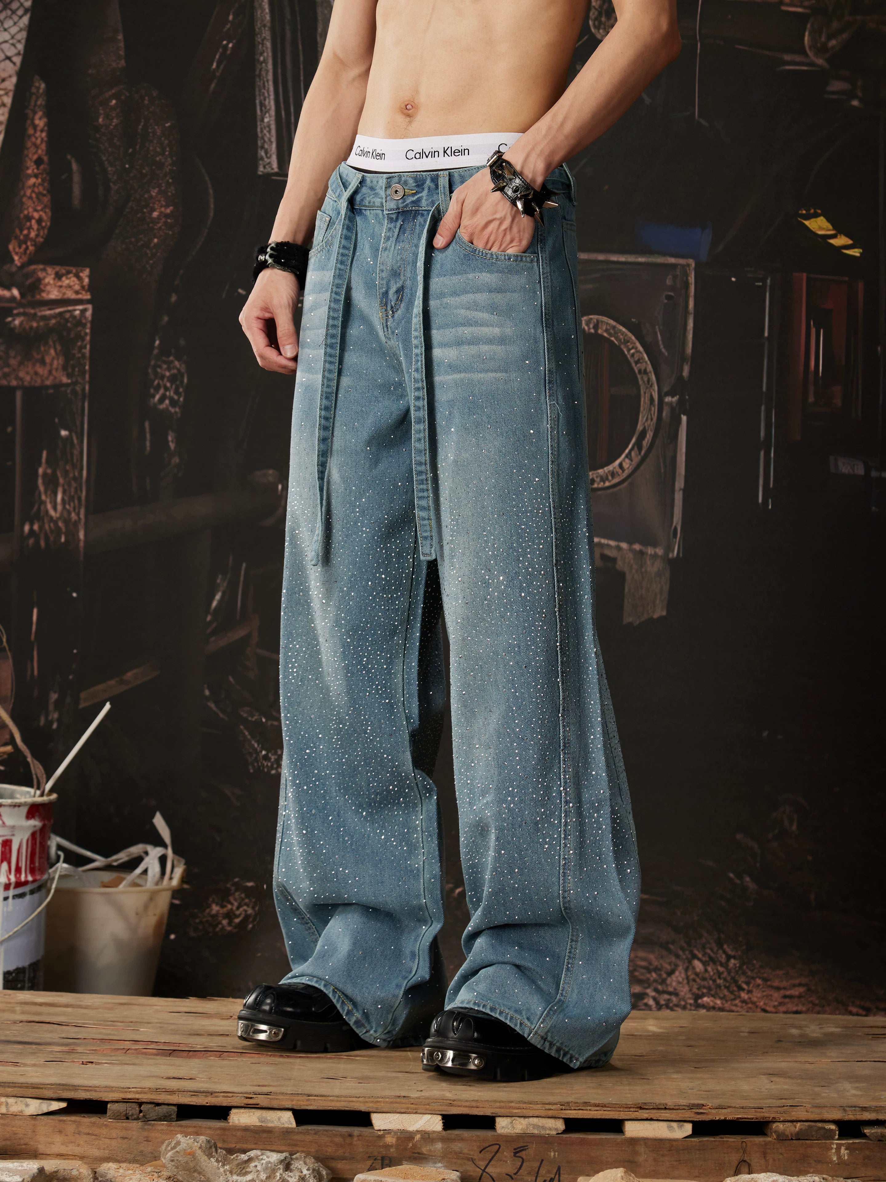 NOMANIAI  Loose-fit, acid-washed, distressed denim jeans featuring rhinestone-studded streamers.