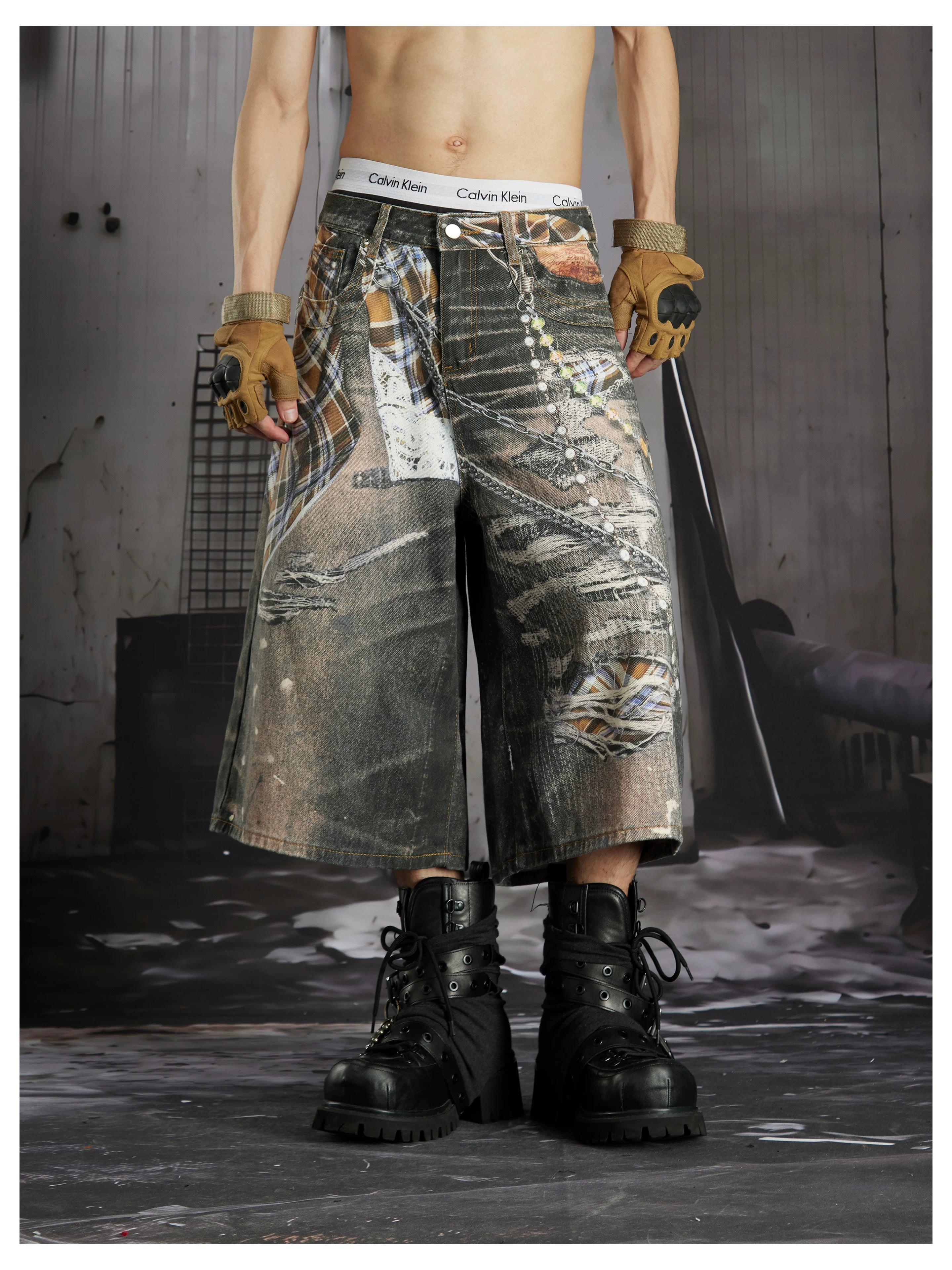 NOMANIAI  Loose-fit cropped trousers featuring a 3D-printed plaid pattern and chain detailing.