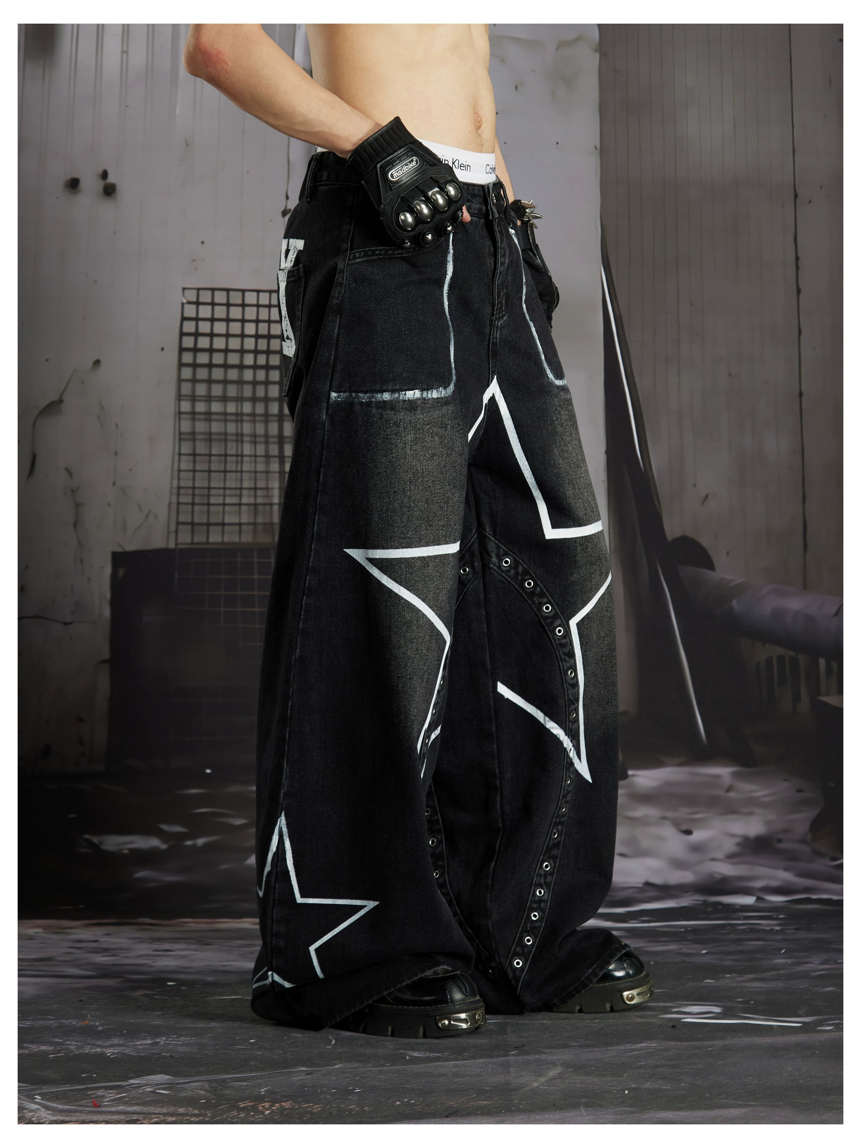 NOMANIAI  Hand-painted star and stud detail wide-leg jeans with a washed, distressed finish.