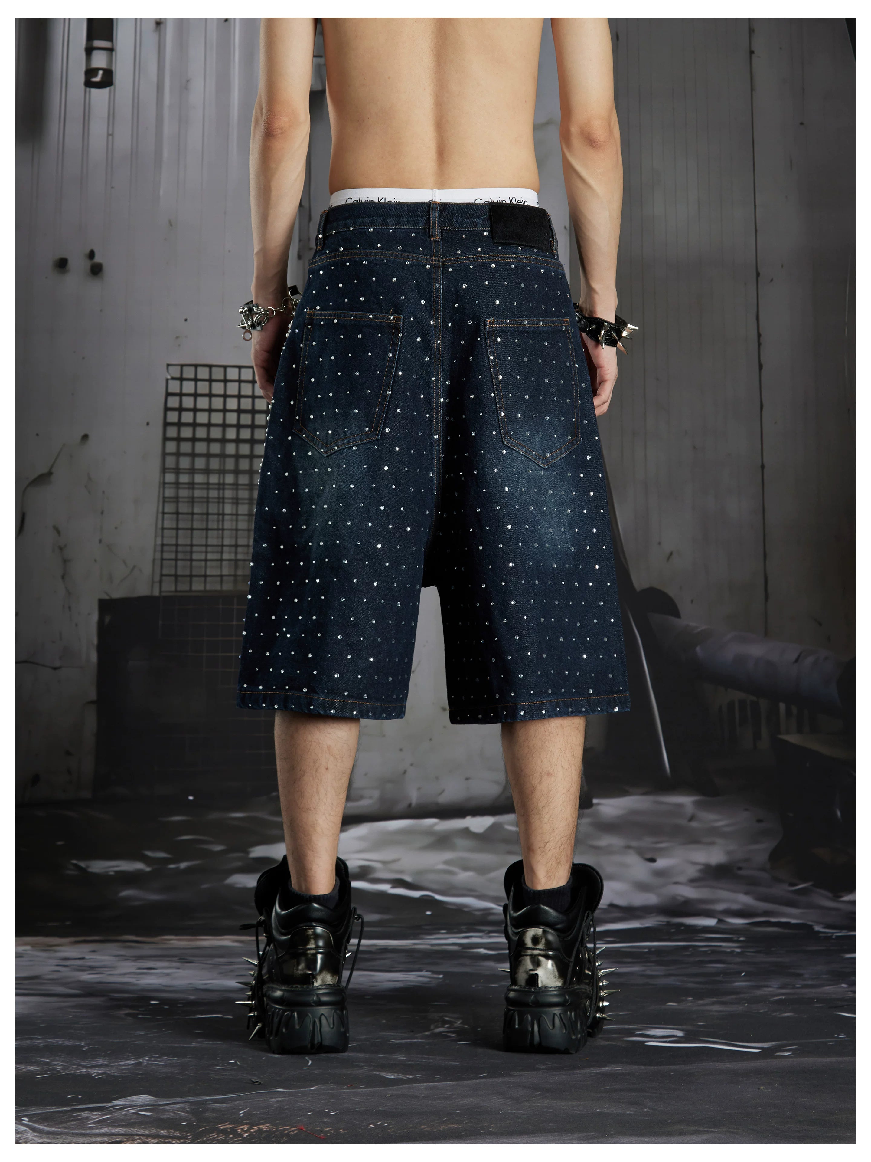NOMANIAI  Oversized, cropped, studded denim jeans with a punk-style distressed wash.