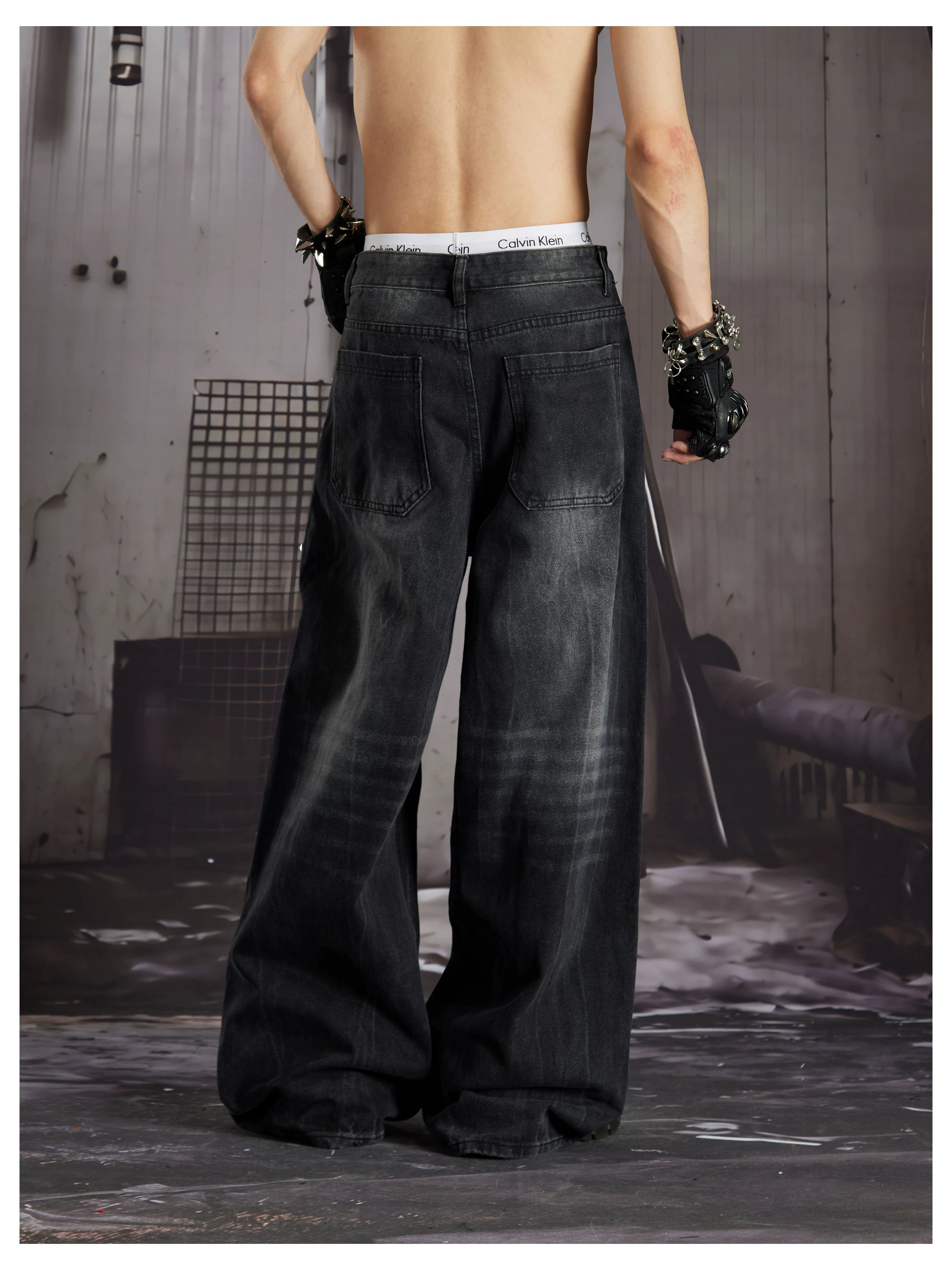 NOMANIAI  Loose-fit, acid-washed, distressed denim jeans with square studs—streetwear style.