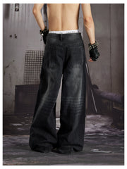 NOMANIAI  Loose-fit, acid-washed, distressed denim jeans with square studs—streetwear style.