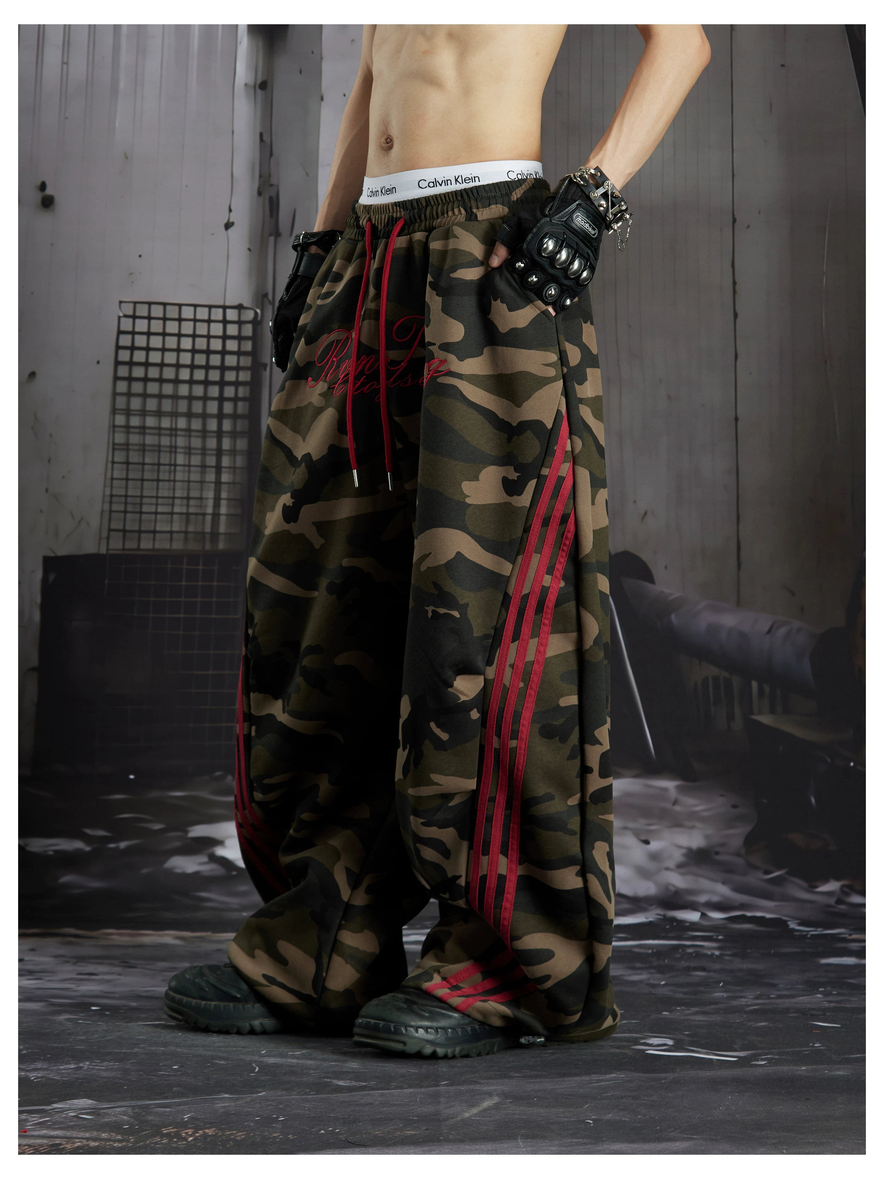 NOMANIAI Street-style embroidered camouflage casual pants with three-stripe detailing.