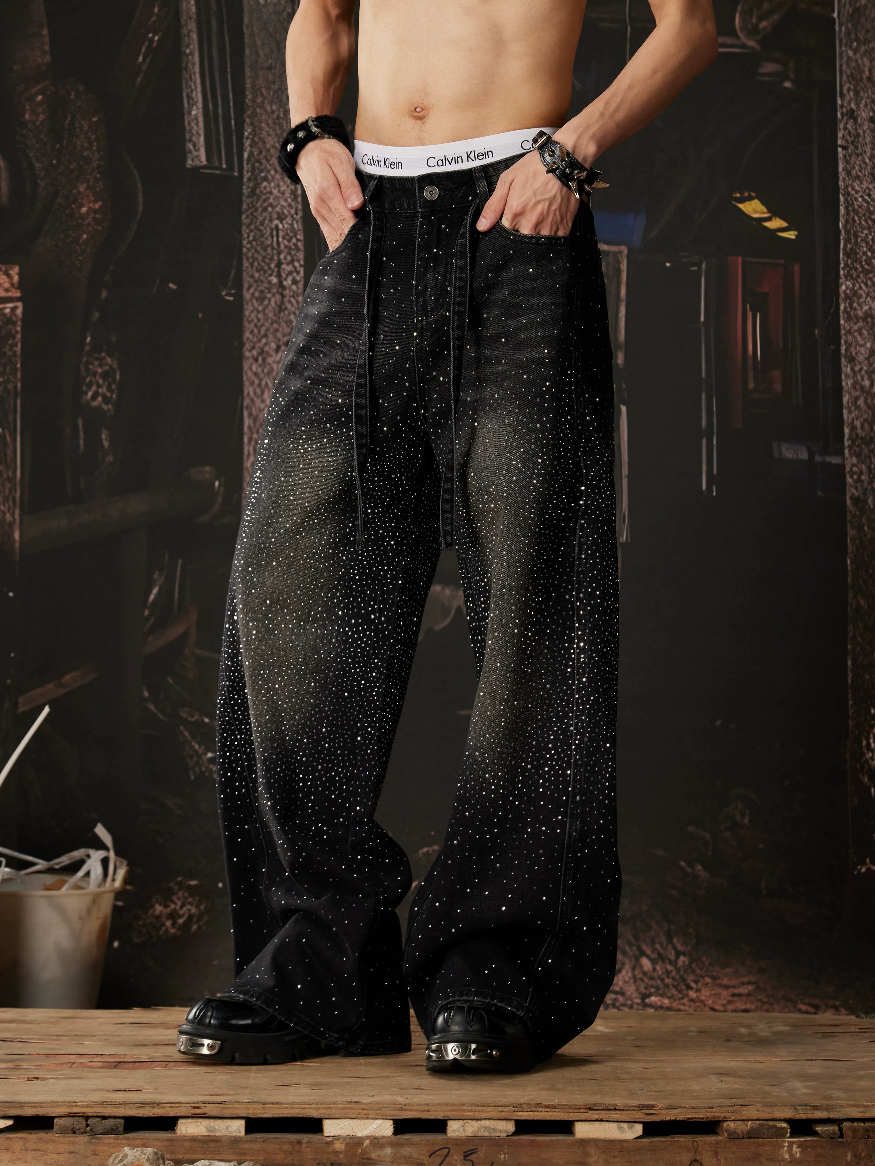 NOMANIAI  Loose-fit, acid-washed, distressed denim jeans featuring rhinestone-studded streamers.