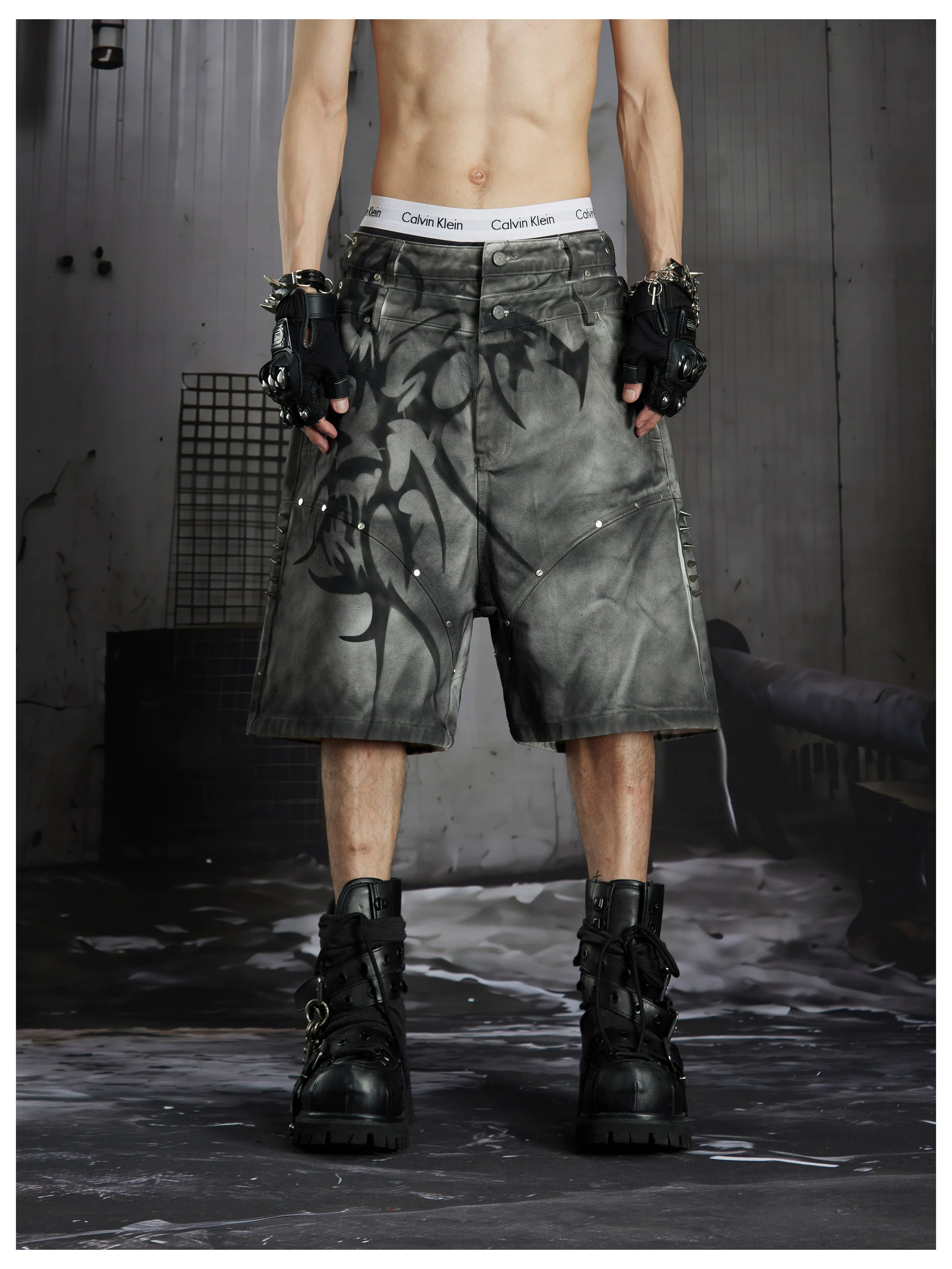 NOMANIAI Y2K loose-fit denim shorts with hand-drawn motifs and studs.