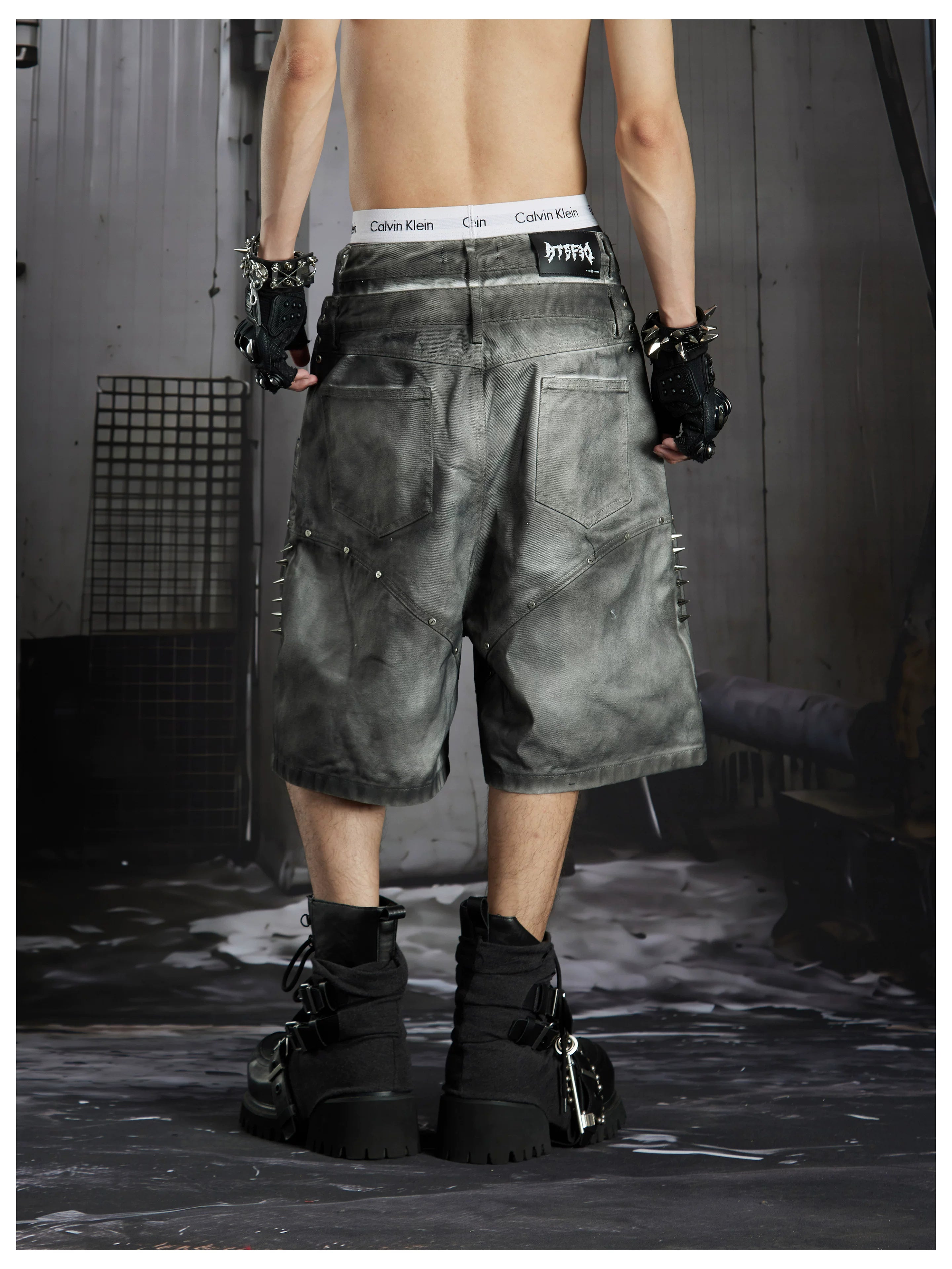 NOMANIAI Y2K loose-fit denim shorts with hand-drawn motifs and studs.