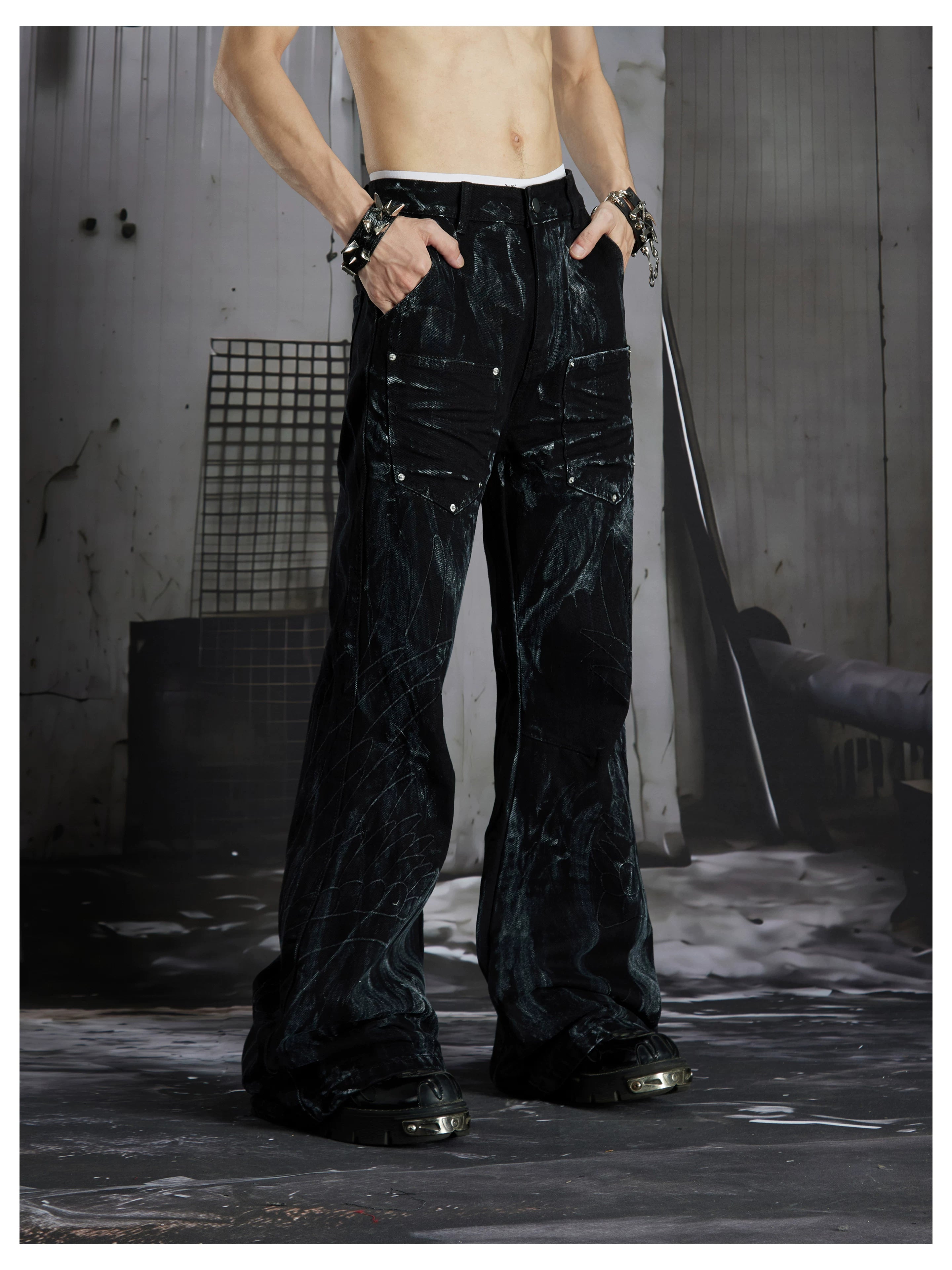 NOMANIAI Edgy, dark-style street-look flared jeans with paint-splatter and stud details.
