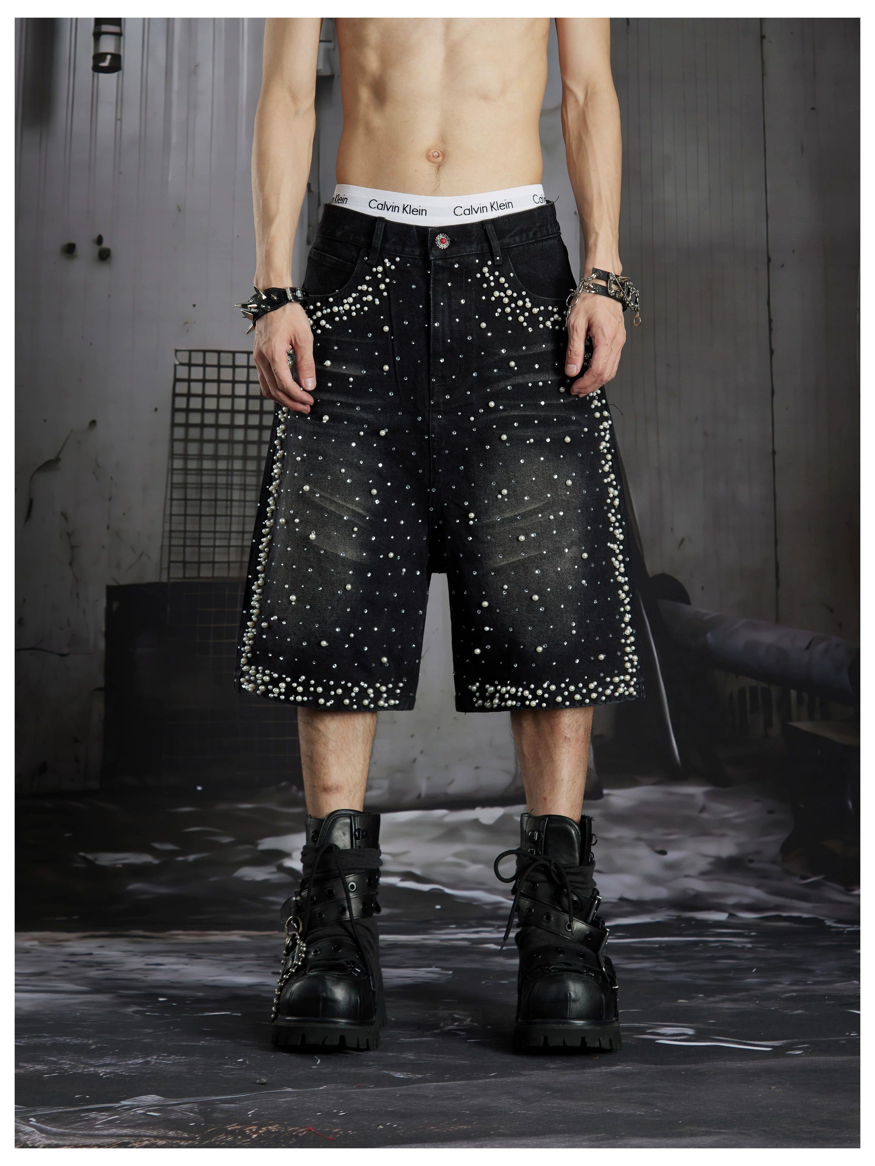 NOMANIAI  Oversized, cropped, studded denim jeans with a punk-style distressed wash.
