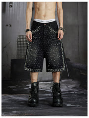 NOMANIAI  Oversized, cropped, studded denim jeans with a punk-style distressed wash.