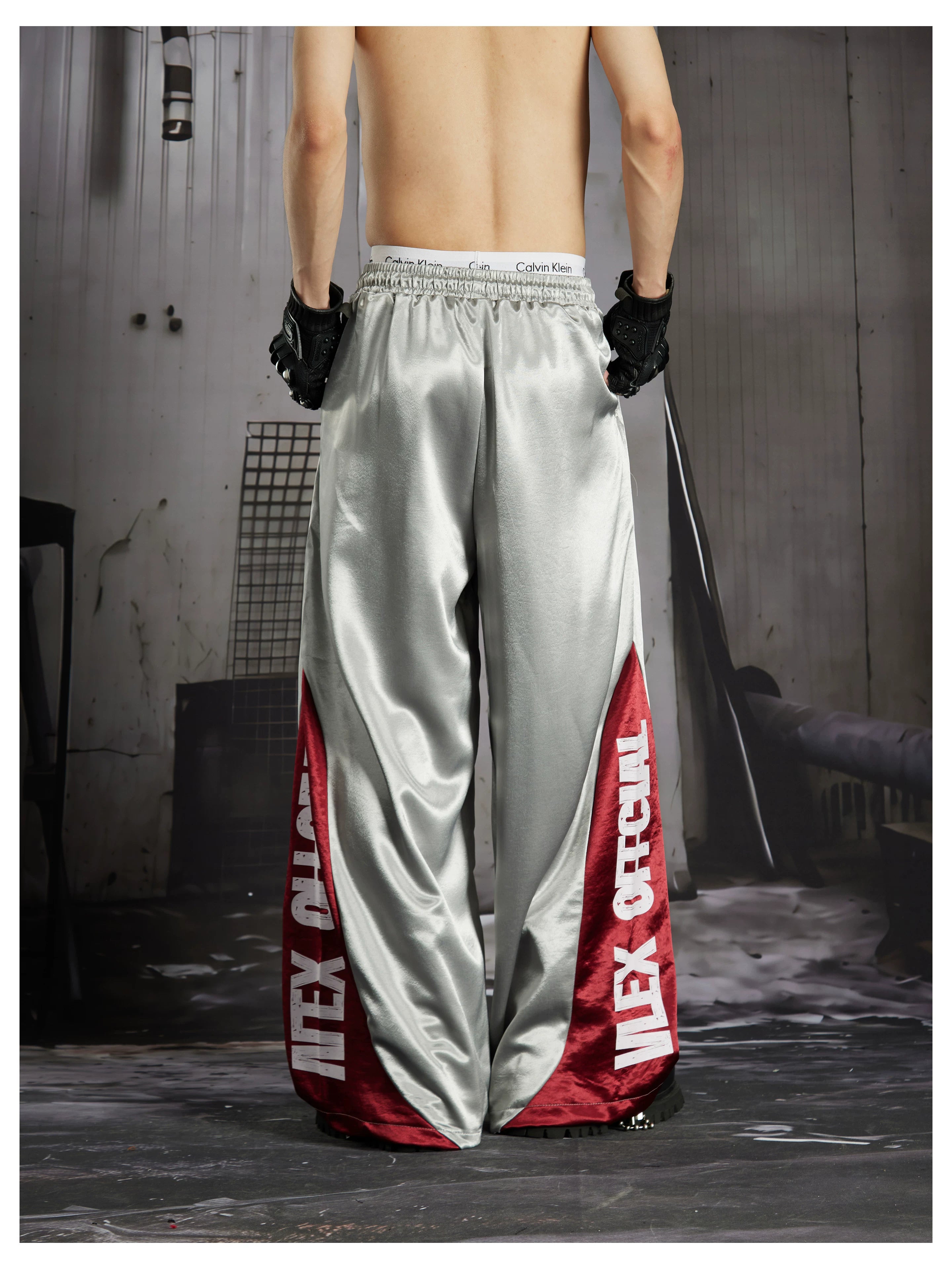 NOMANIAI Street-style casual pants featuring a draped fit, paneling, and a print design.