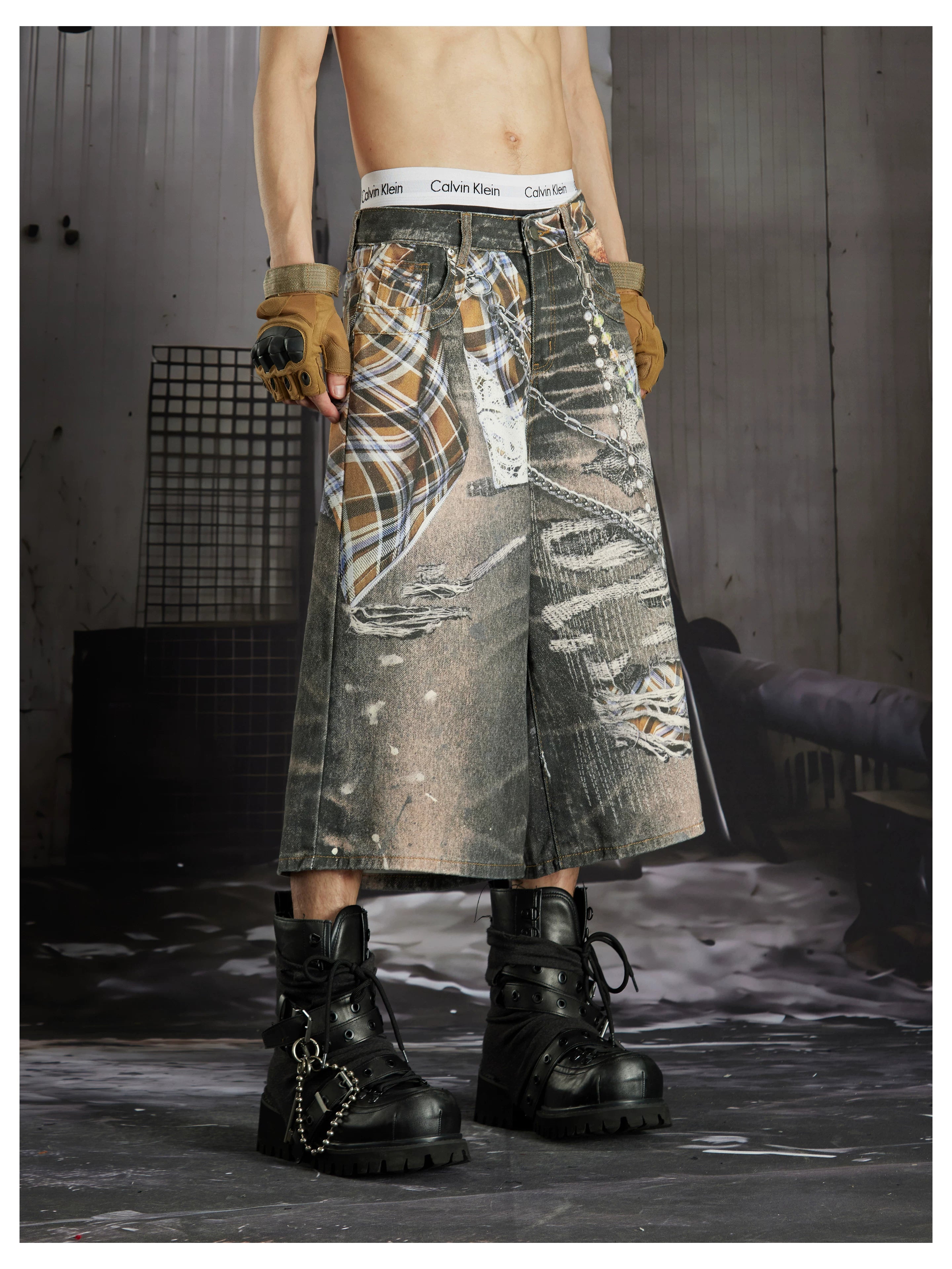 NOMANIAI  Loose-fit cropped trousers featuring a 3D-printed plaid pattern and chain detailing.