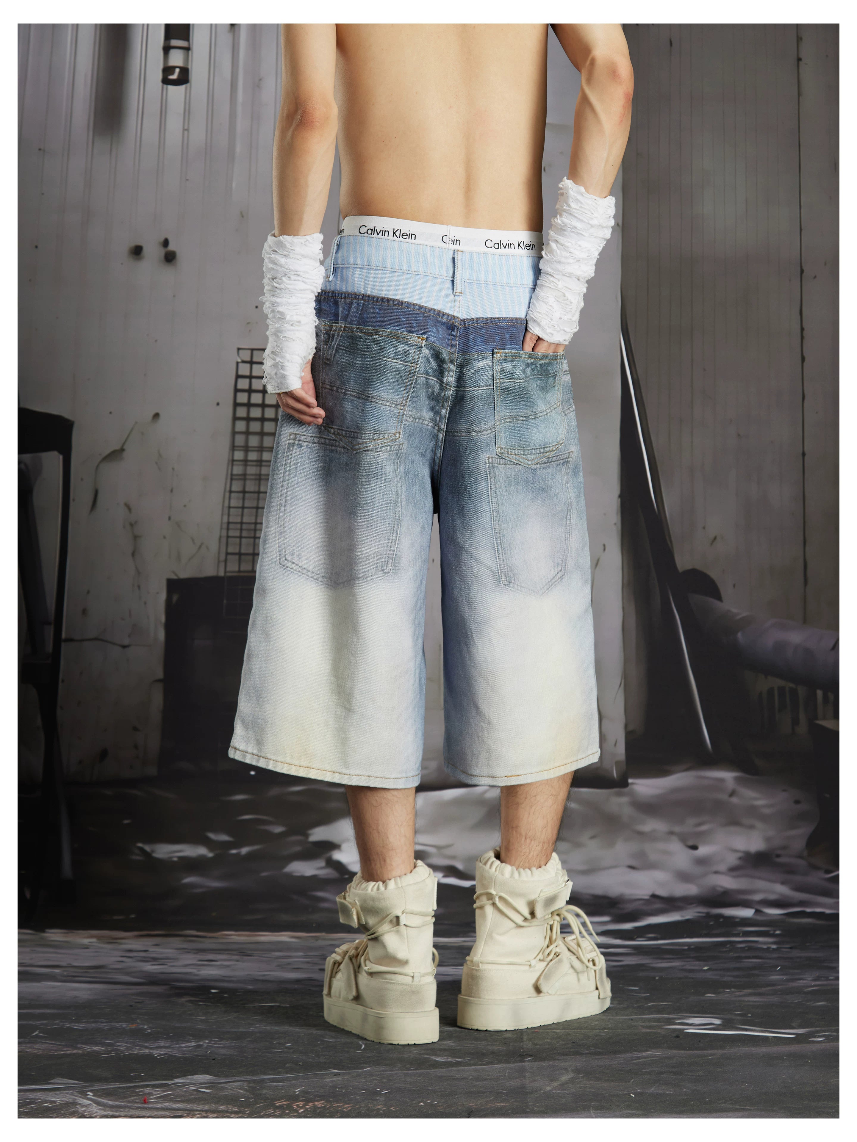 NOMANIAI Y2K-style loose-fit cropped pants featuring a triple-waistband design and chain charm detail.