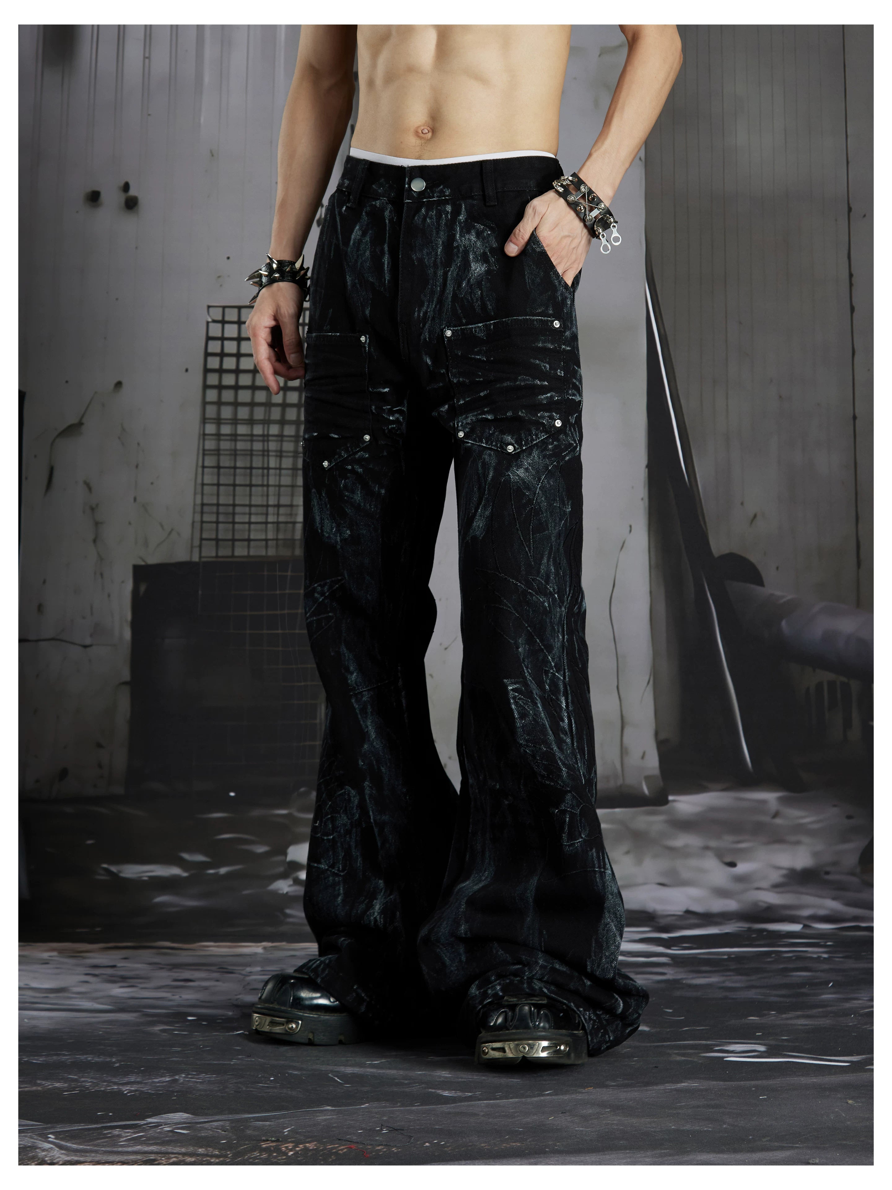 NOMANIAI Edgy, dark-style street-look flared jeans with paint-splatter and stud details.