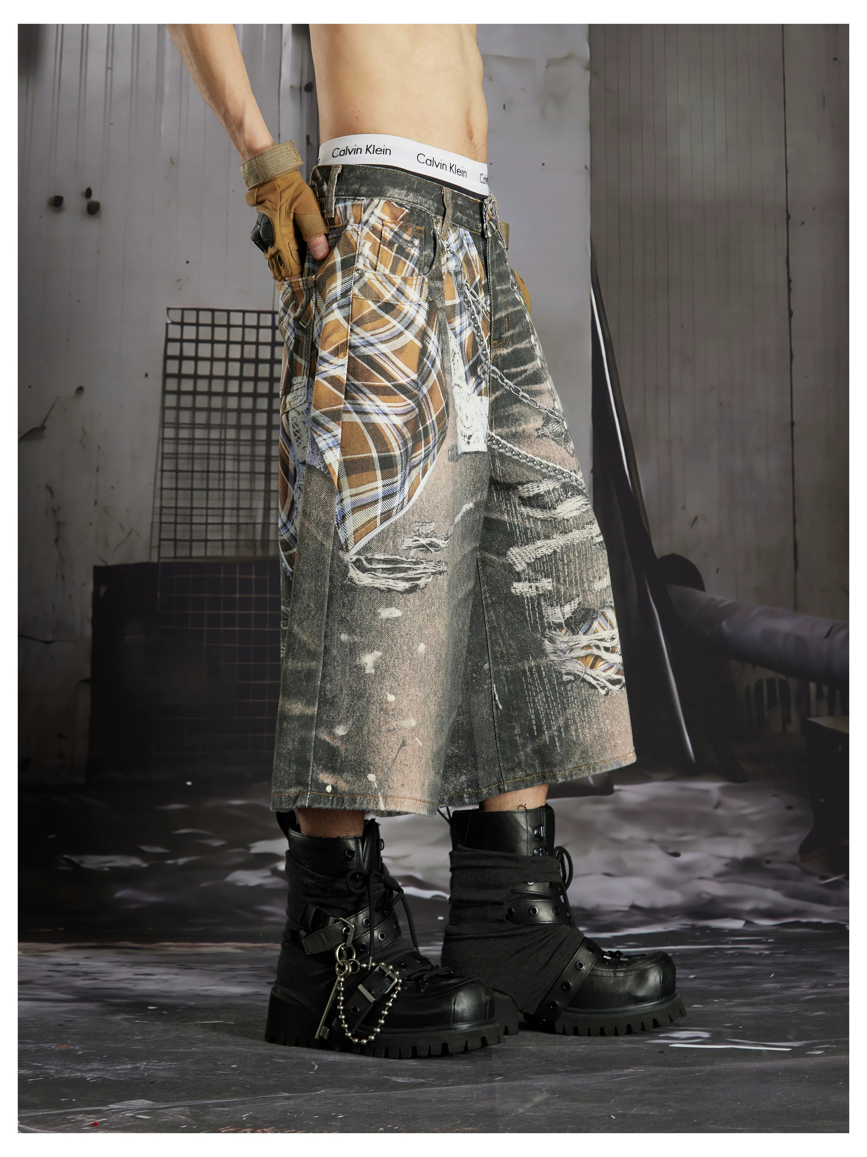 NOMANIAI  Loose-fit cropped trousers featuring a 3D-printed plaid pattern and chain detailing.