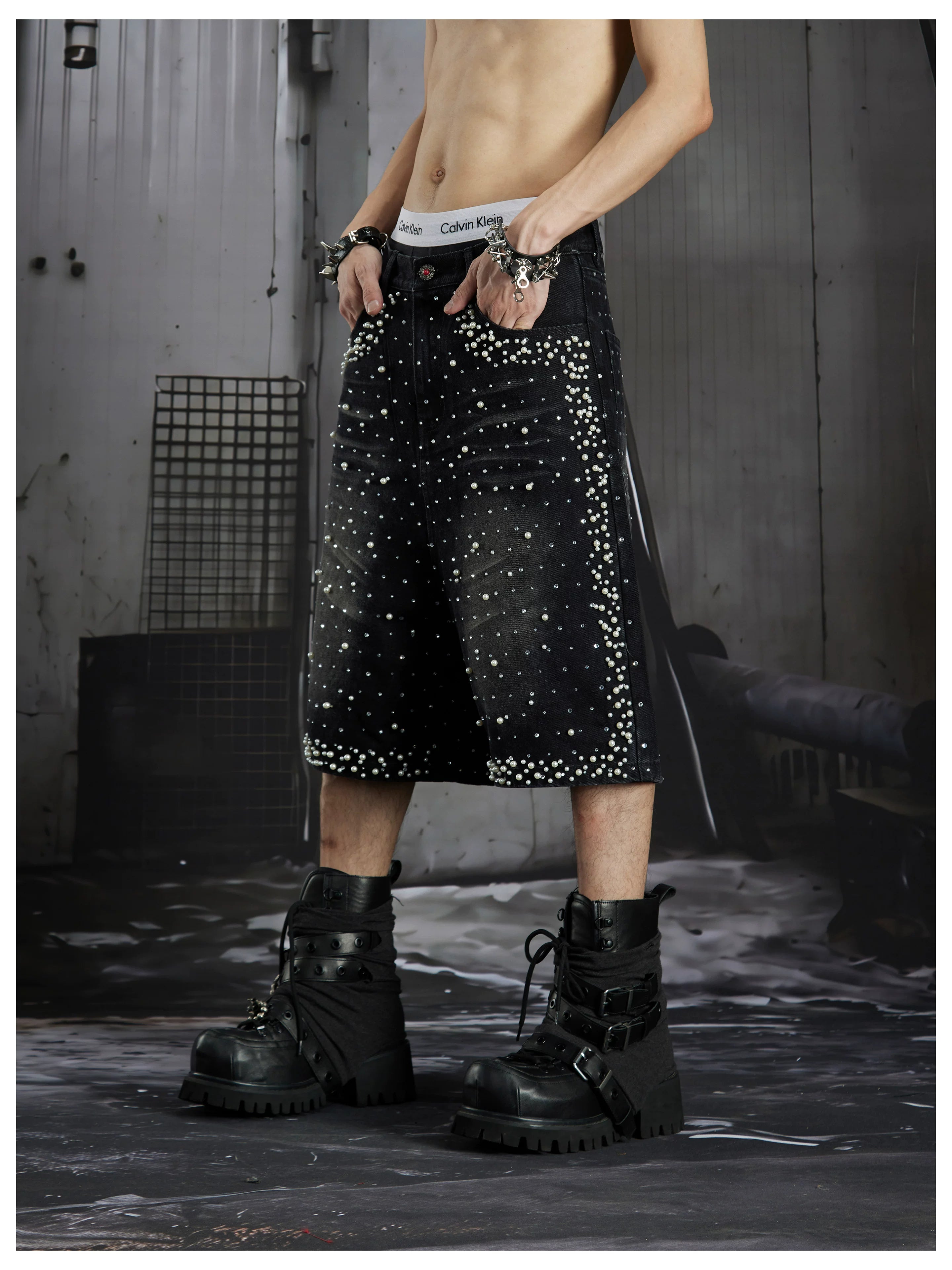 NOMANIAI  Oversized, cropped, studded denim jeans with a punk-style distressed wash.