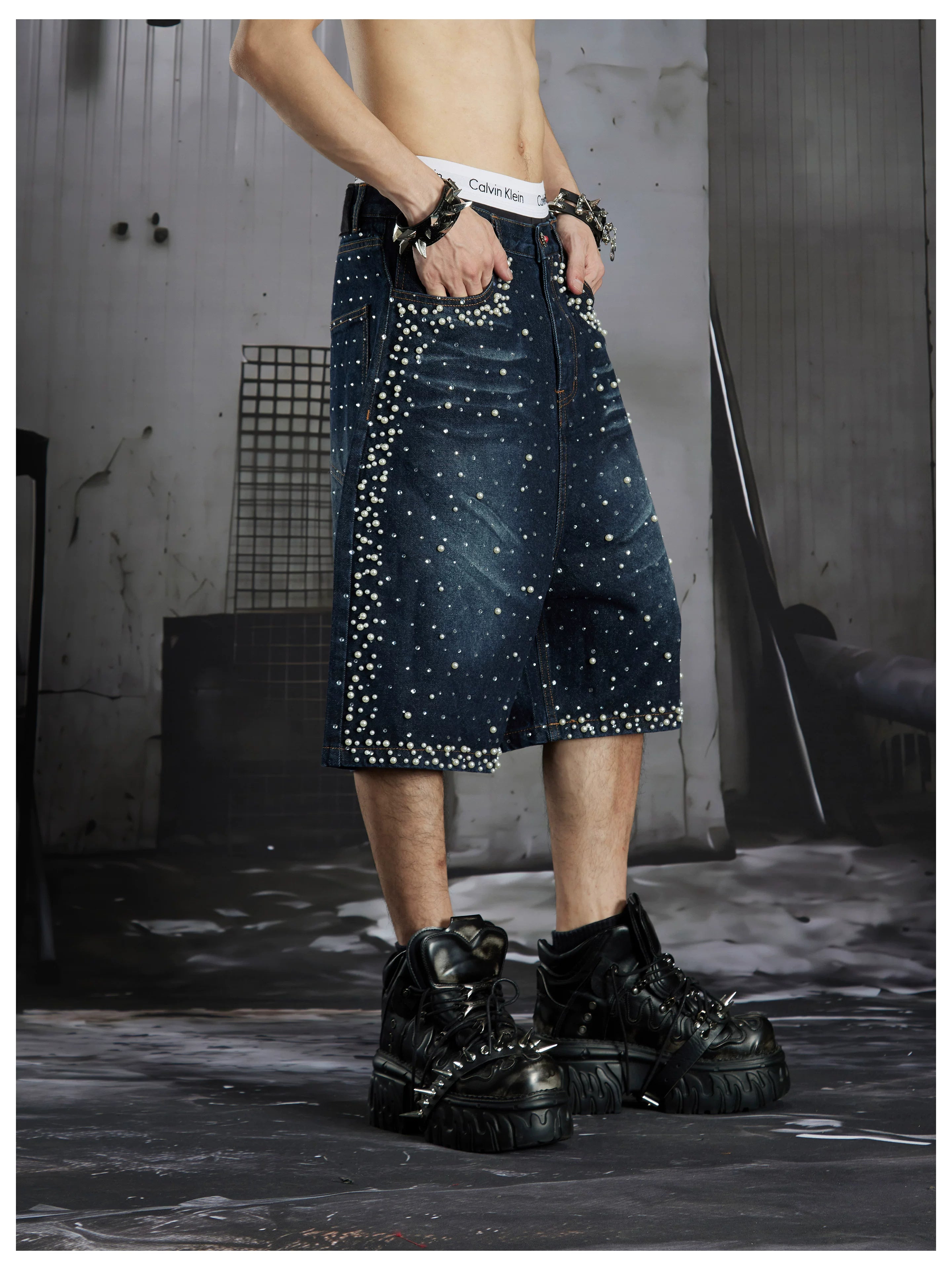 NOMANIAI  Oversized, cropped, studded denim jeans with a punk-style distressed wash.