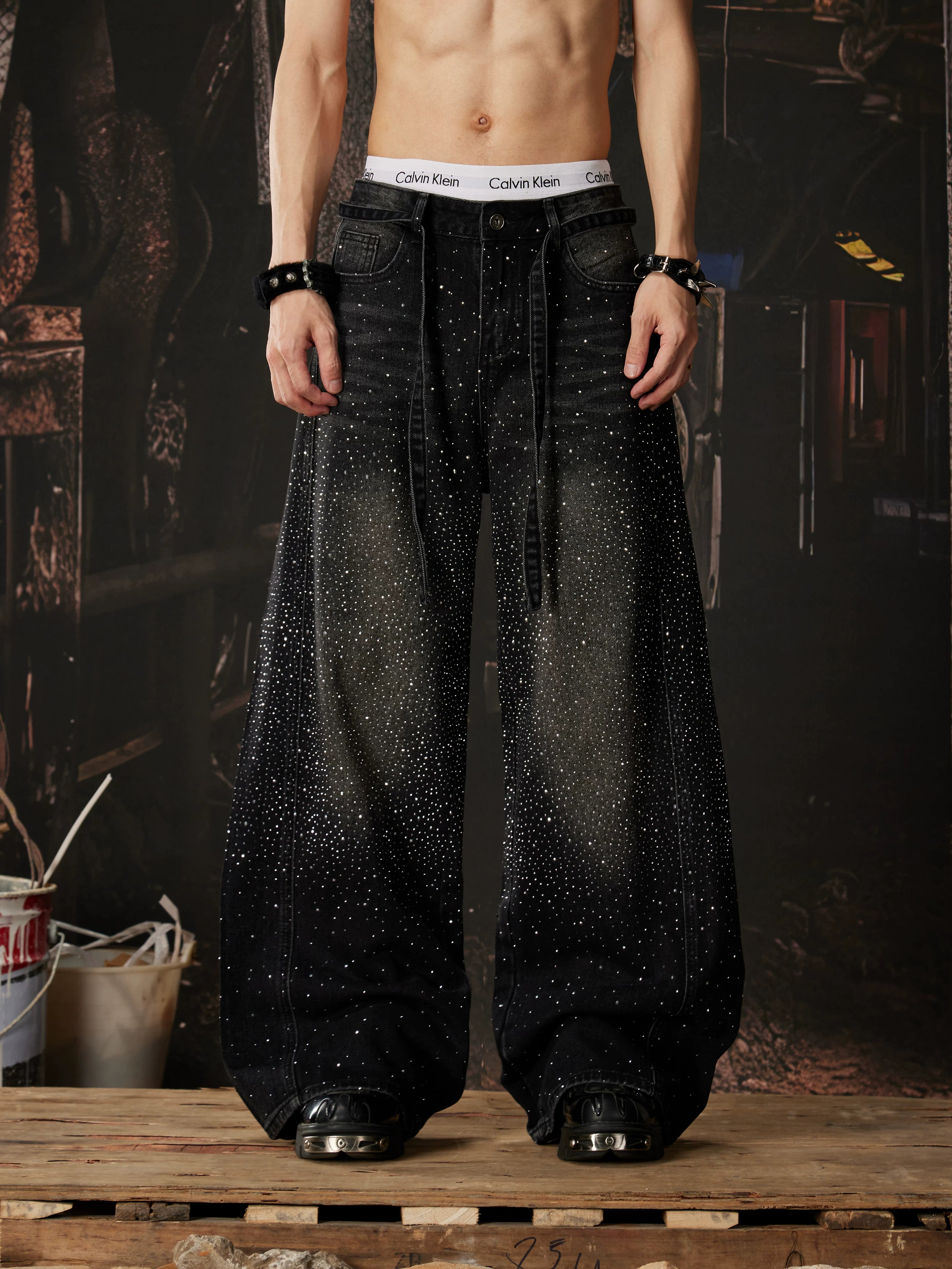 NOMANIAI  Loose-fit, acid-washed, distressed denim jeans featuring rhinestone-studded streamers.