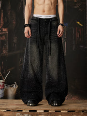 NOMANIAI  Loose-fit, acid-washed, distressed denim jeans featuring rhinestone-studded streamers.